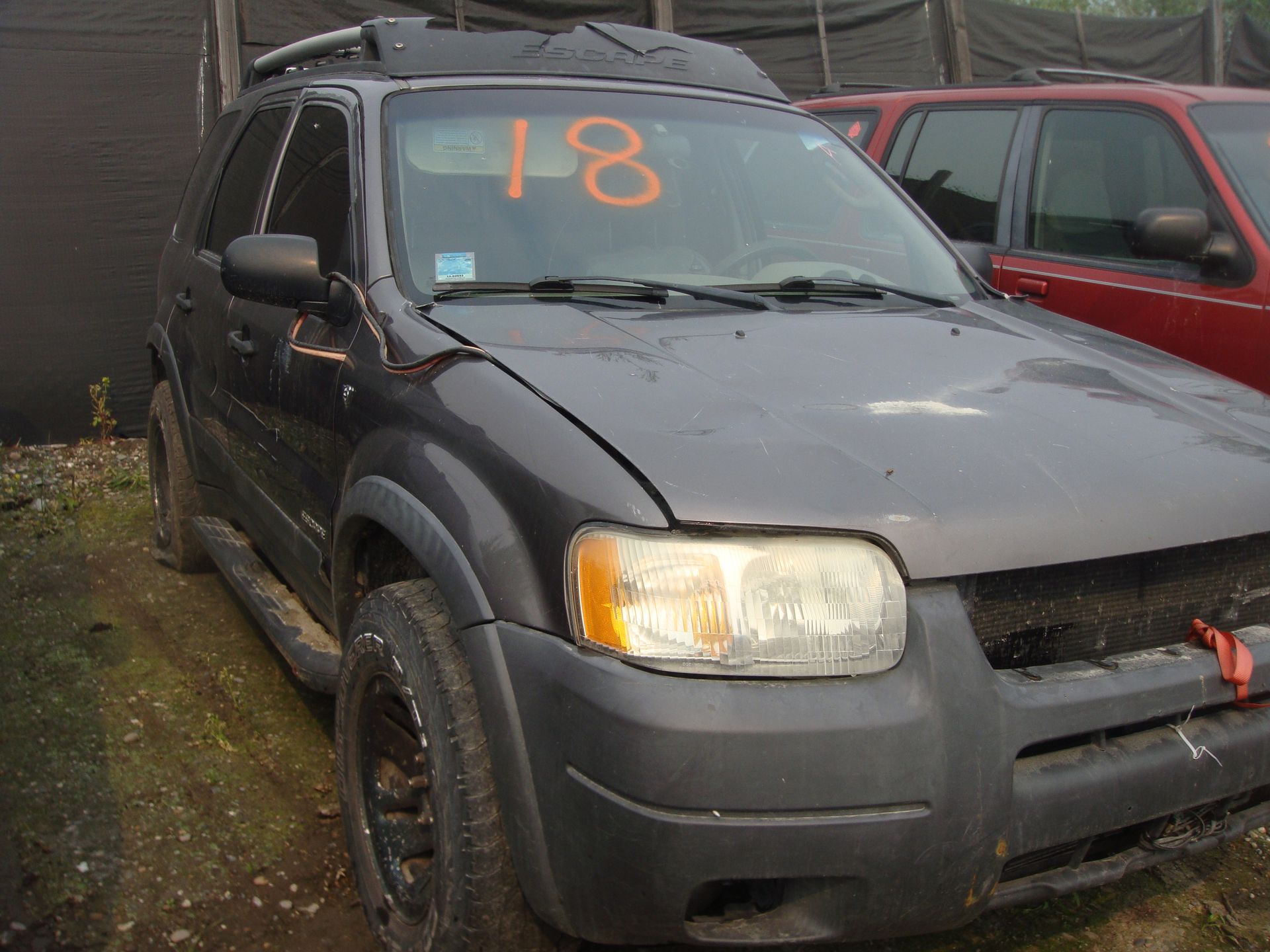 A black suv with the number 18 on the windshield