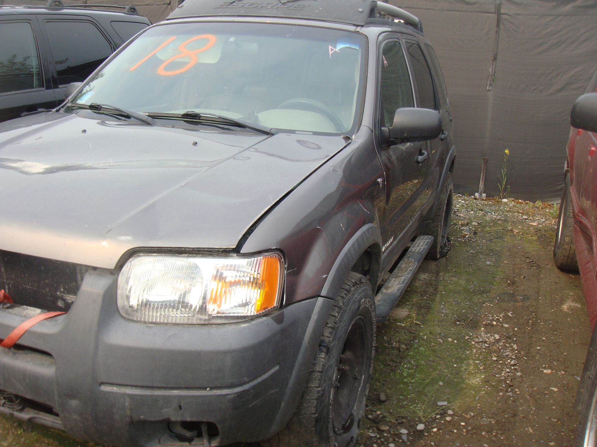 A gray ford escape with the number 18 on the windshield