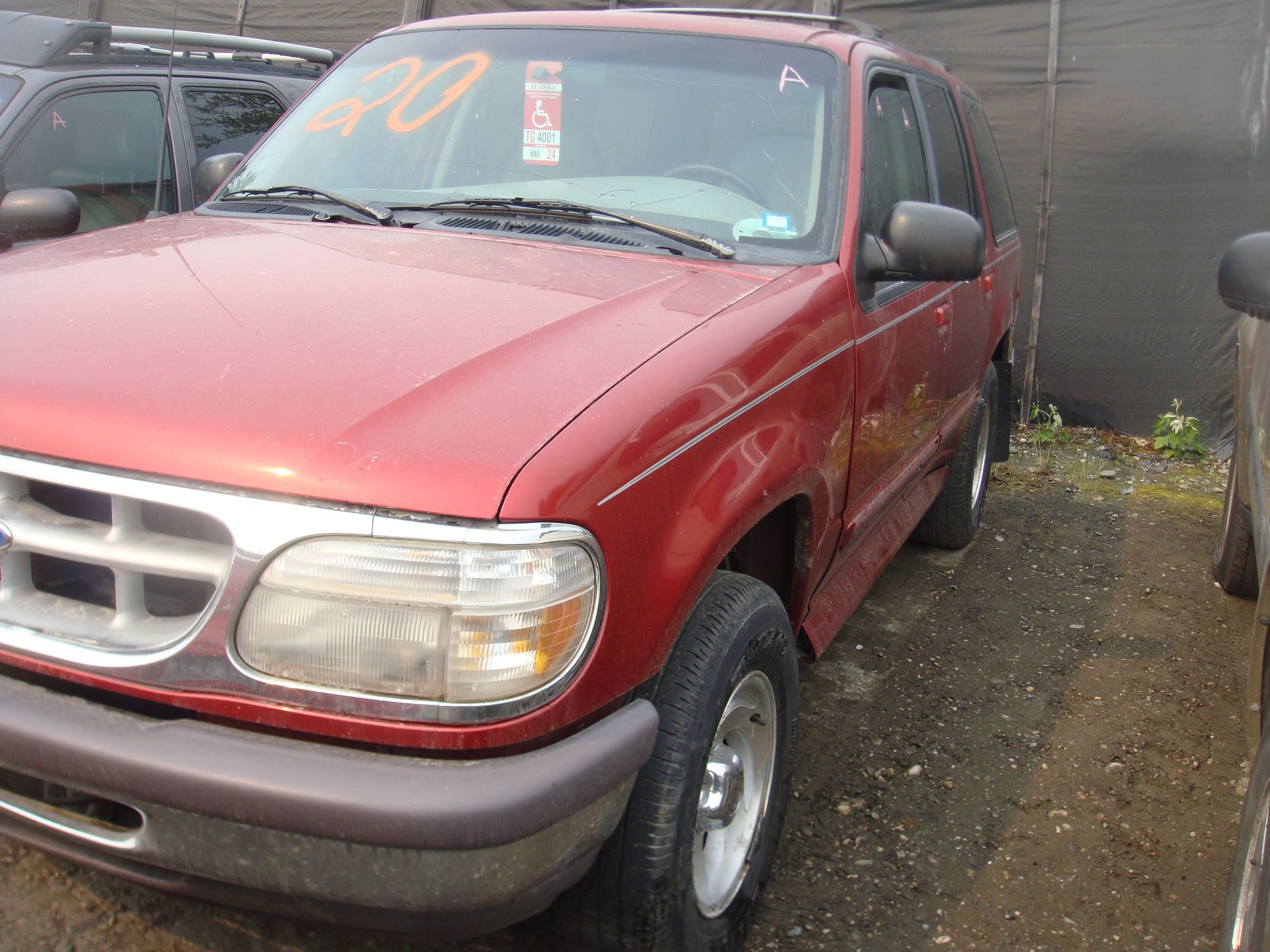 A red ford explorer is parked in a lot