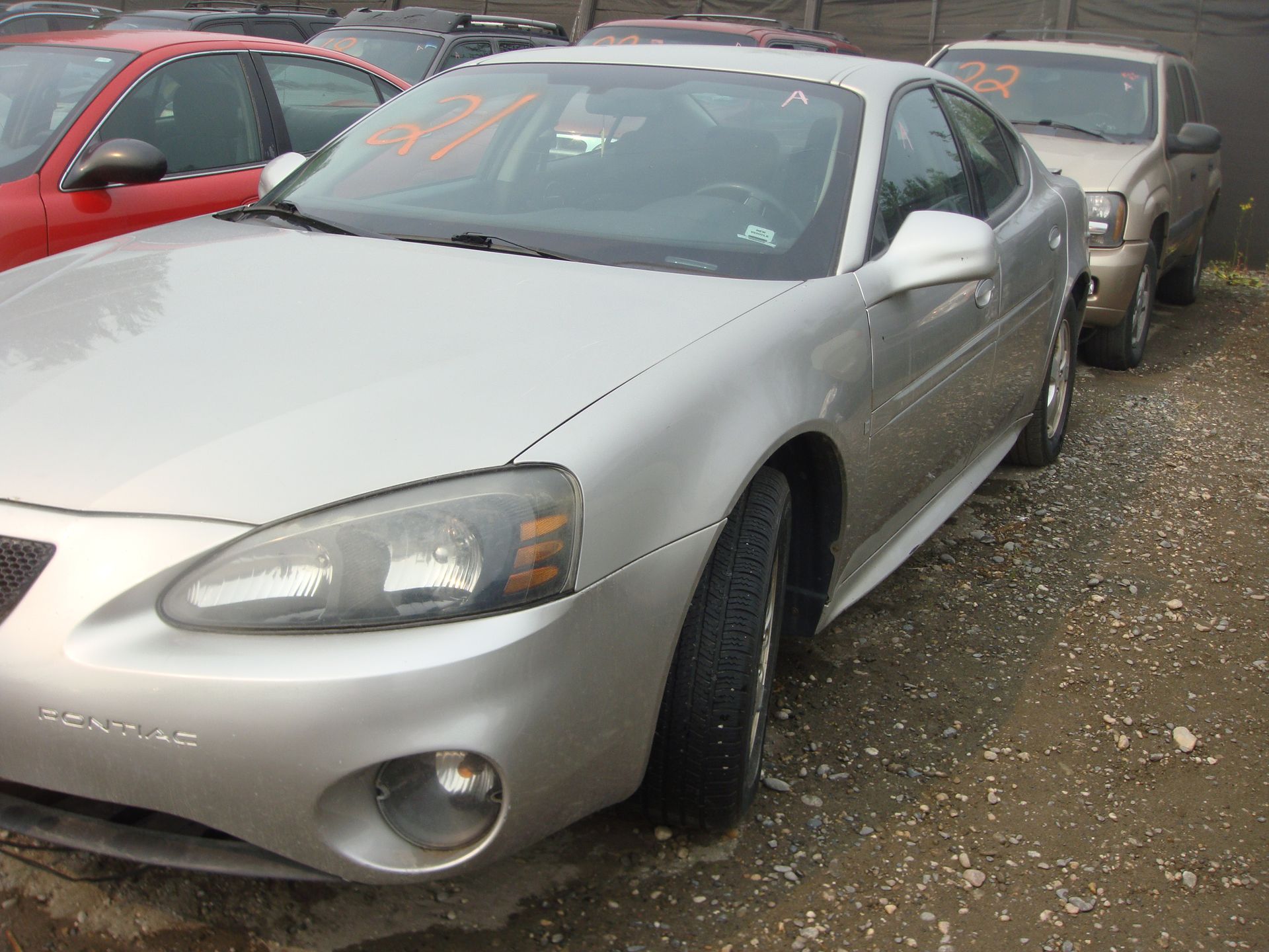 A silver car with the number 53 on the windshield