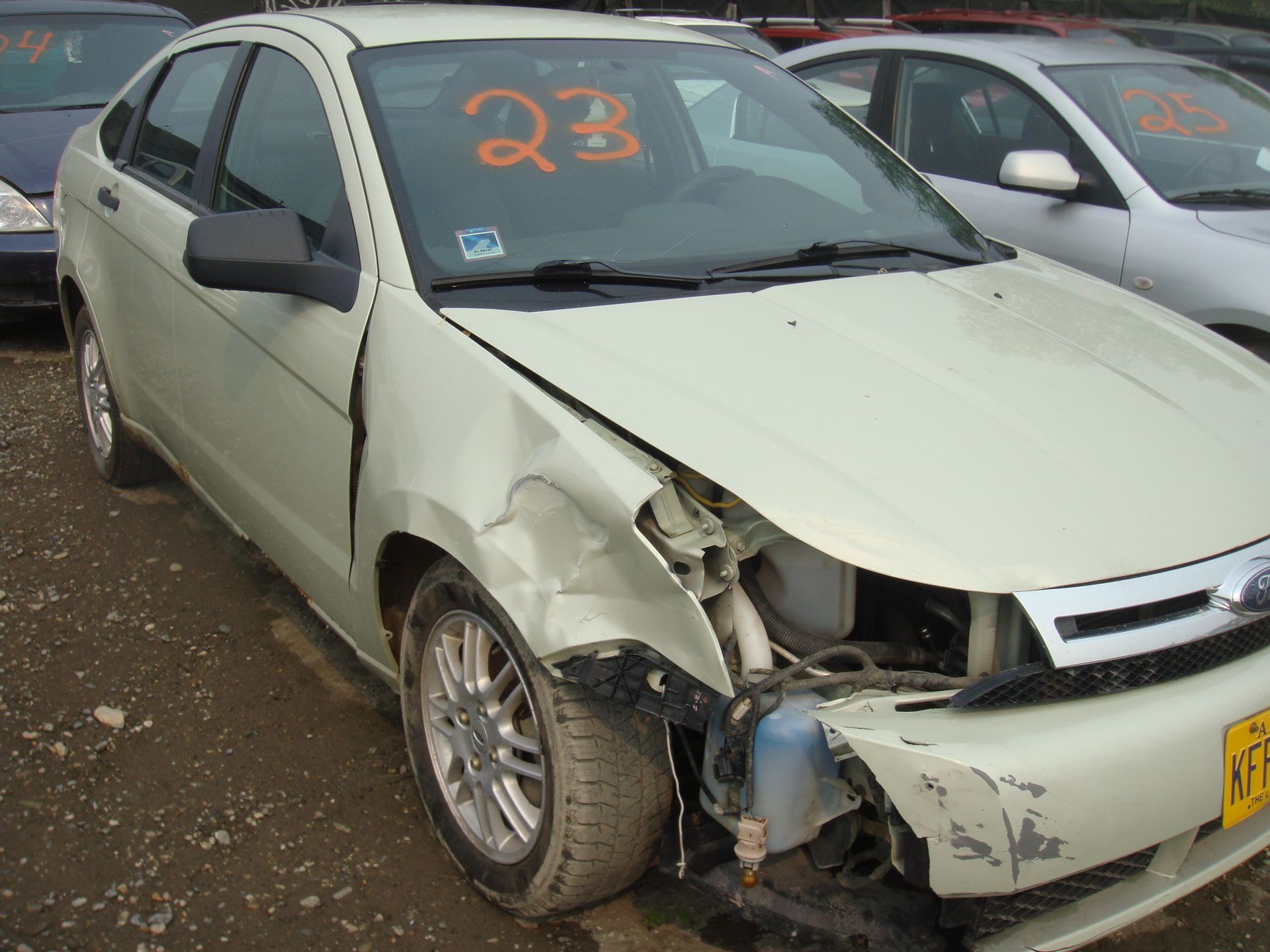 A white car with the number 23 on the windshield