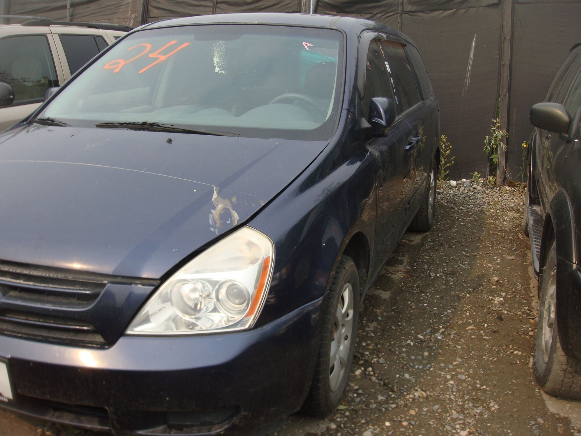A blue car with the number 24 on the windshield