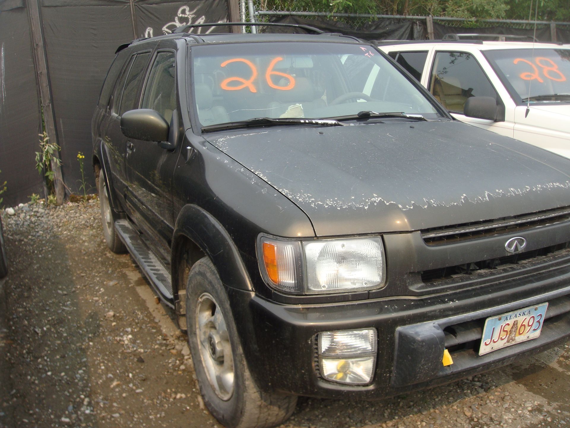 A black suv with the number 26 on the windshield