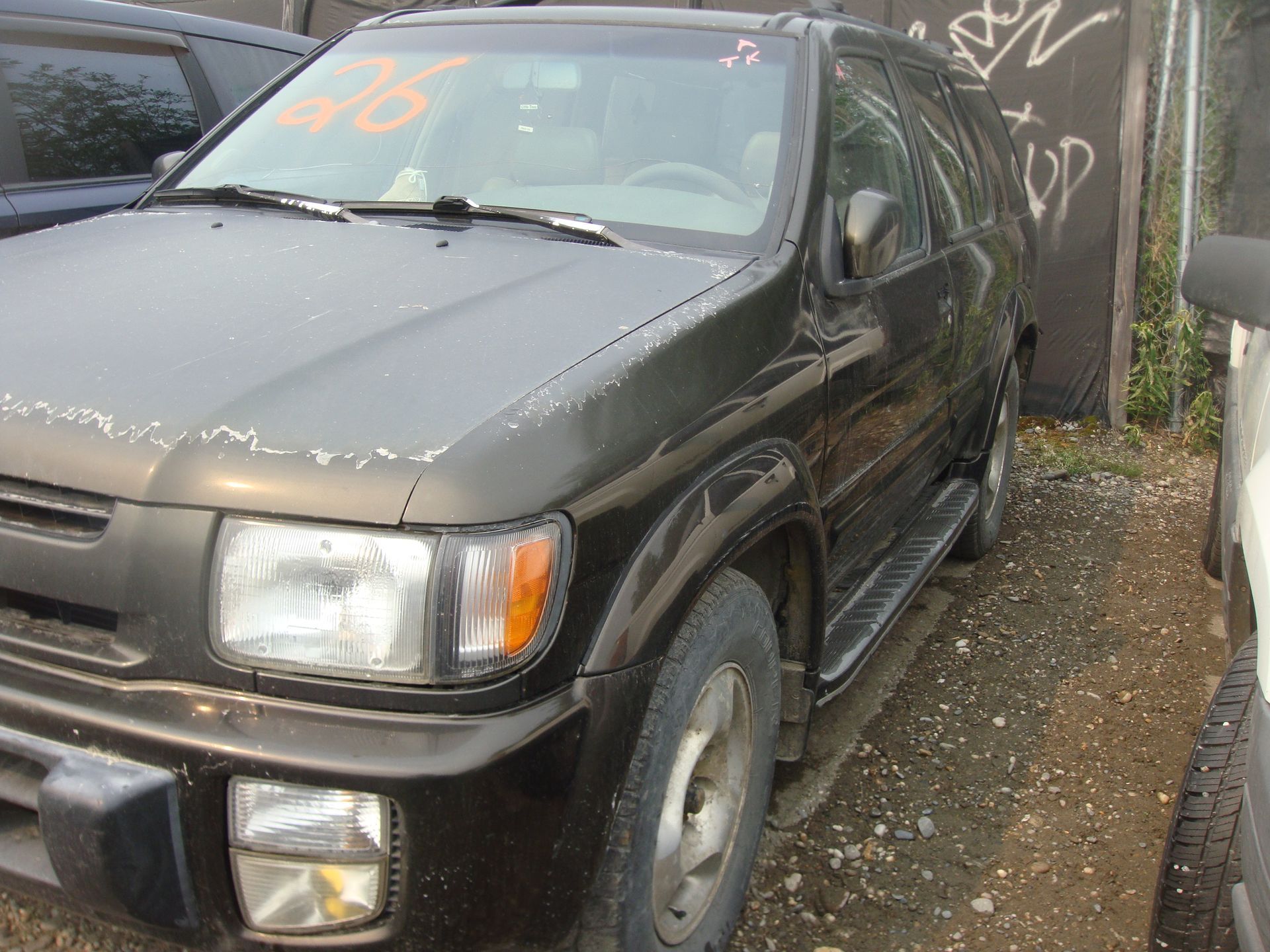 A black suv with the number 26 on the windshield
