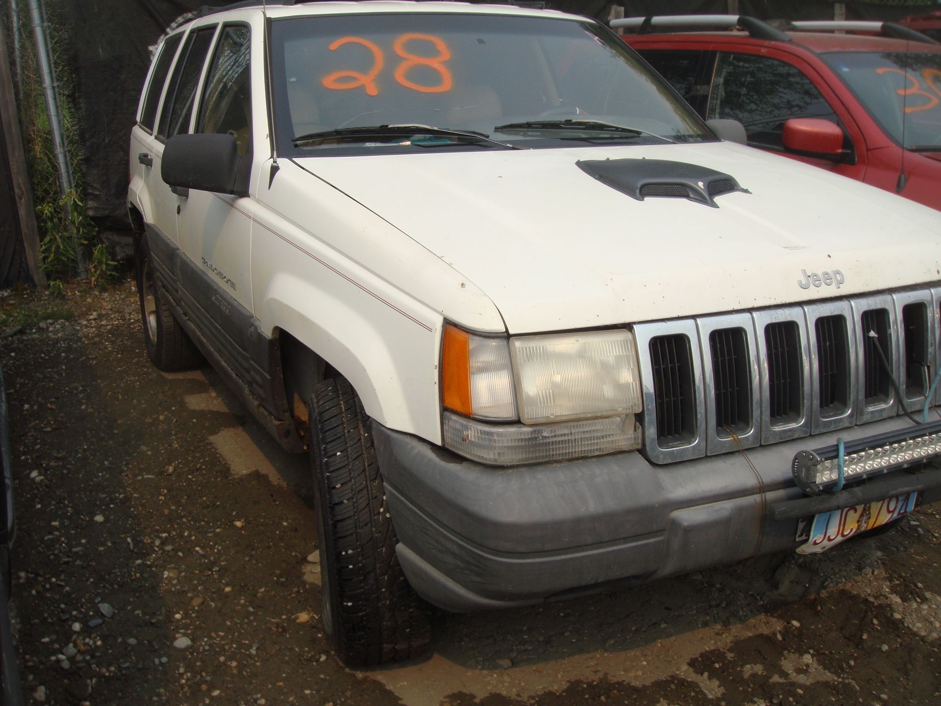 A white jeep with the number 28 on the windshield