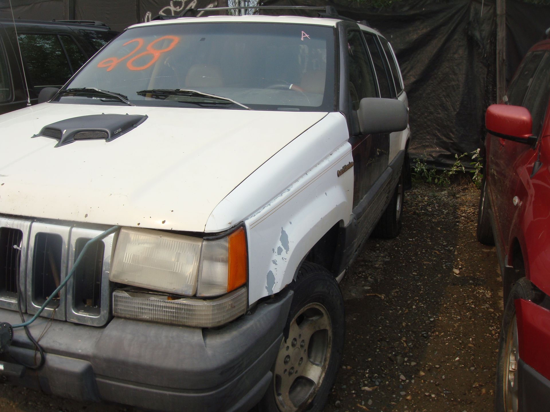 A white jeep with the number 28 on the windshield
