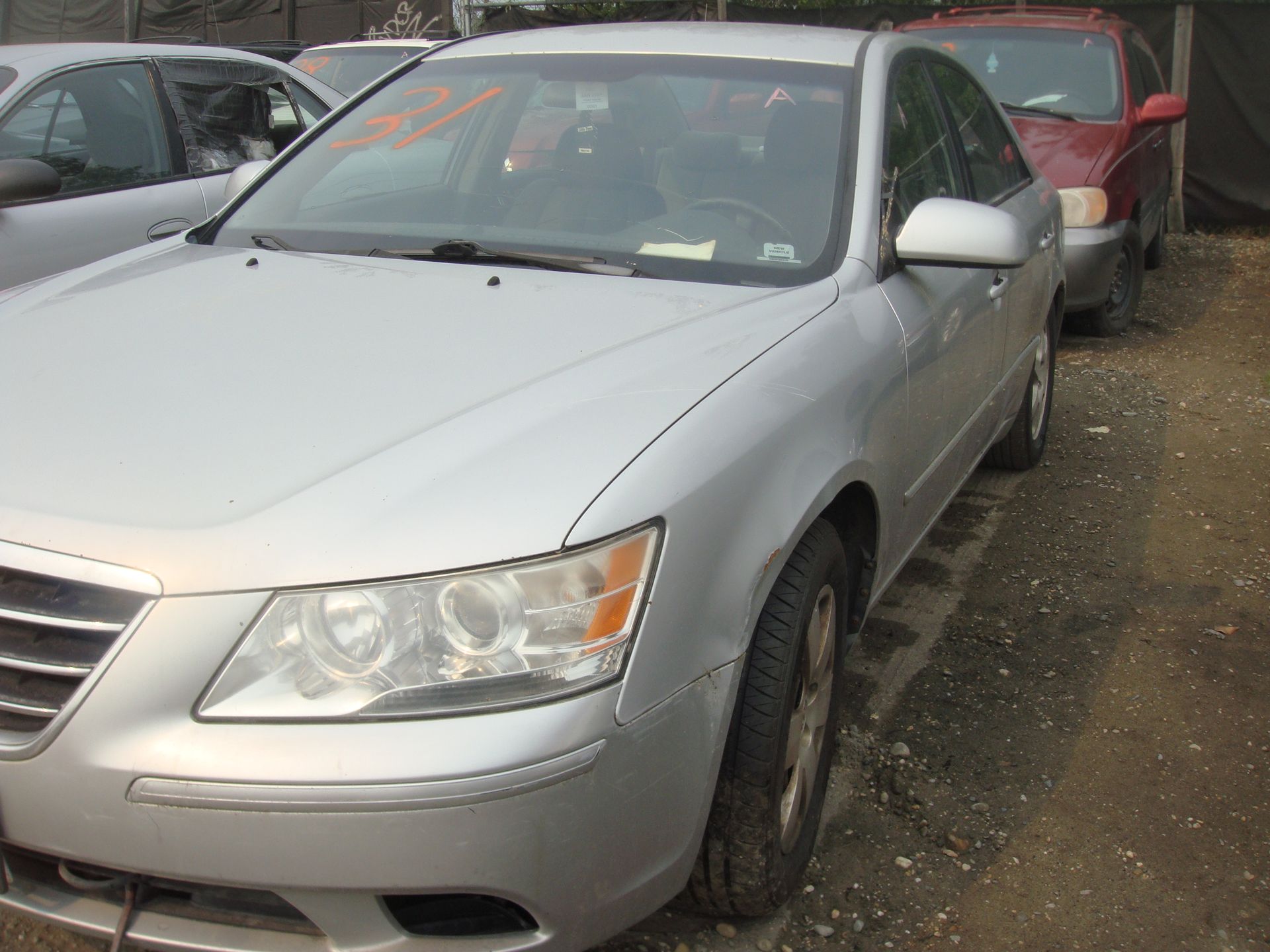 A silver car is parked in a lot with other cars