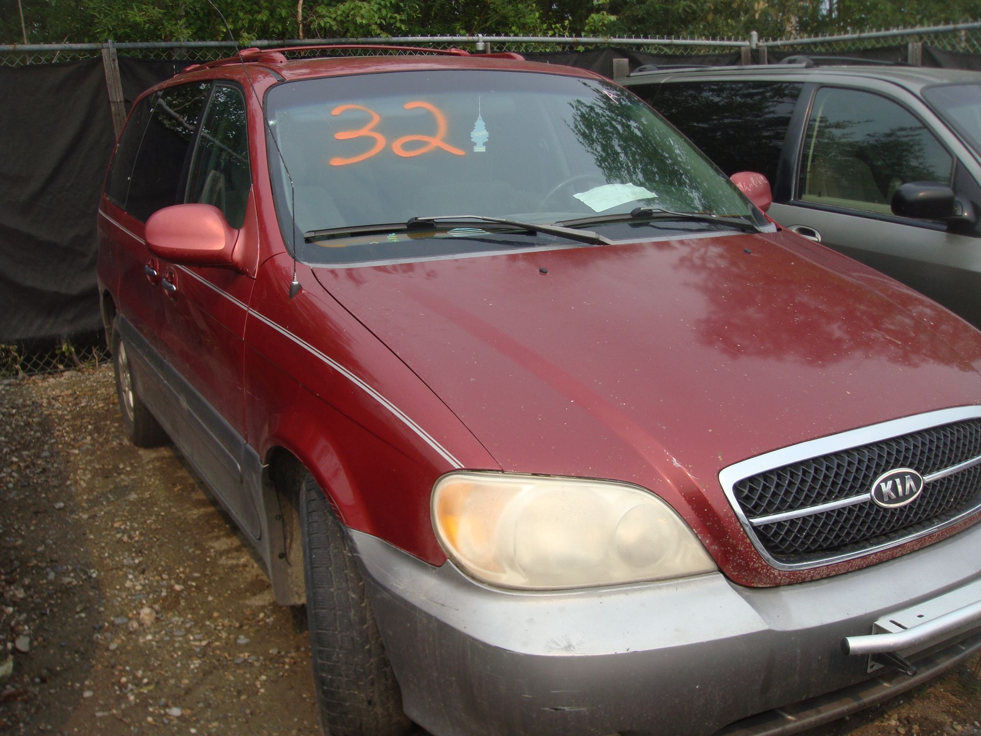 A red car with the number 32 on the windshield