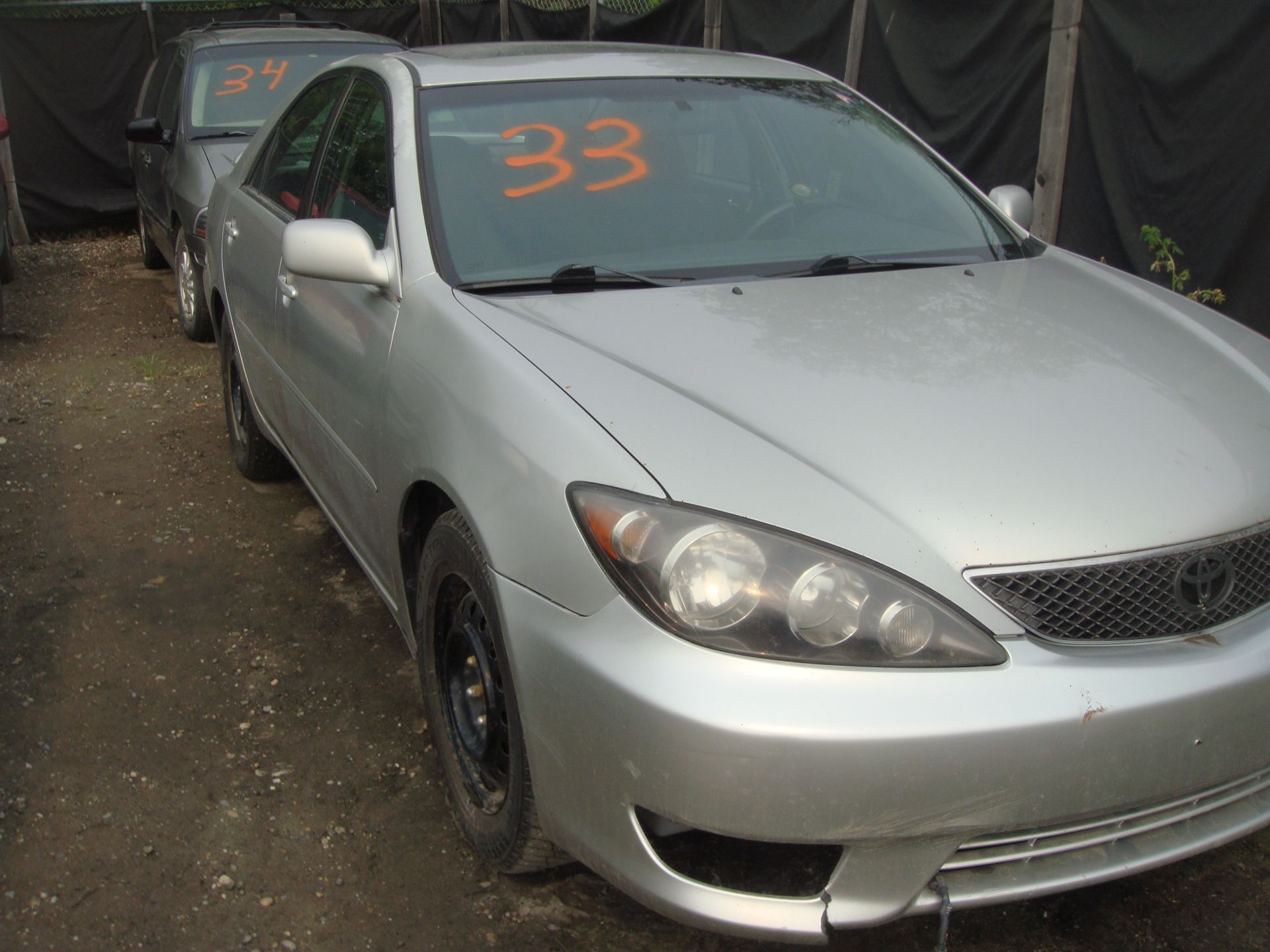 A silver car with the number 33 on the windshield
