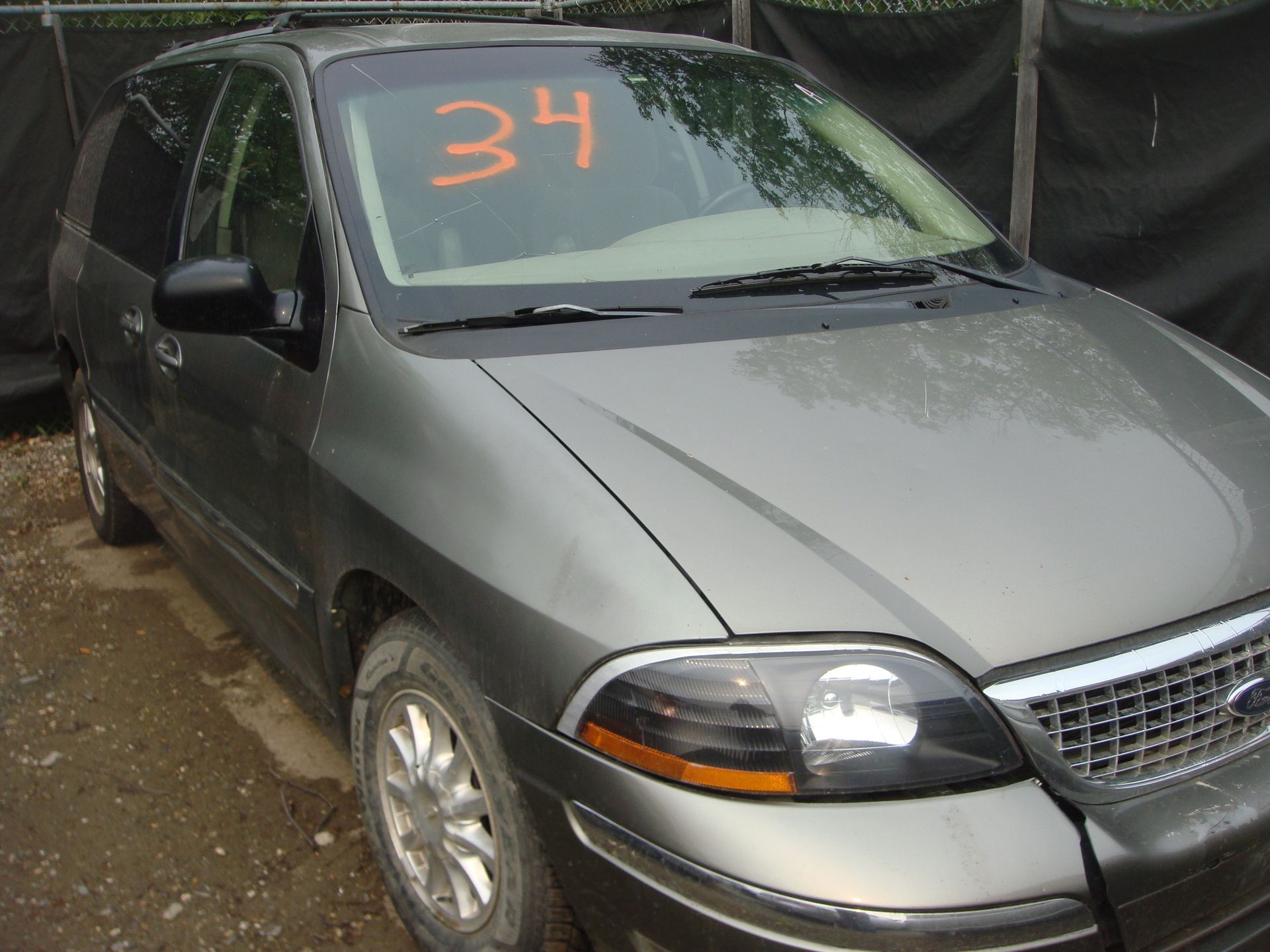 A gray car with the number 34 on the windshield