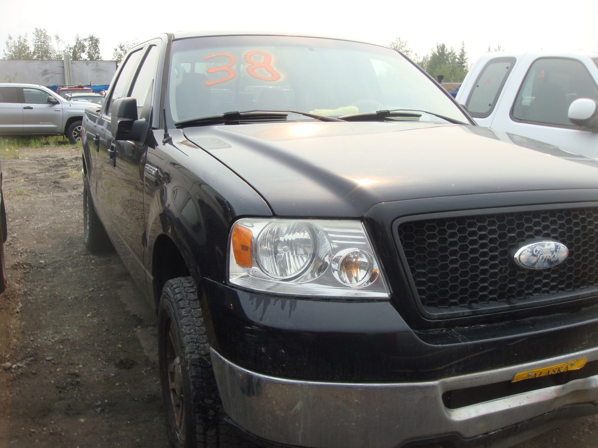 A black ford truck is parked in a lot
