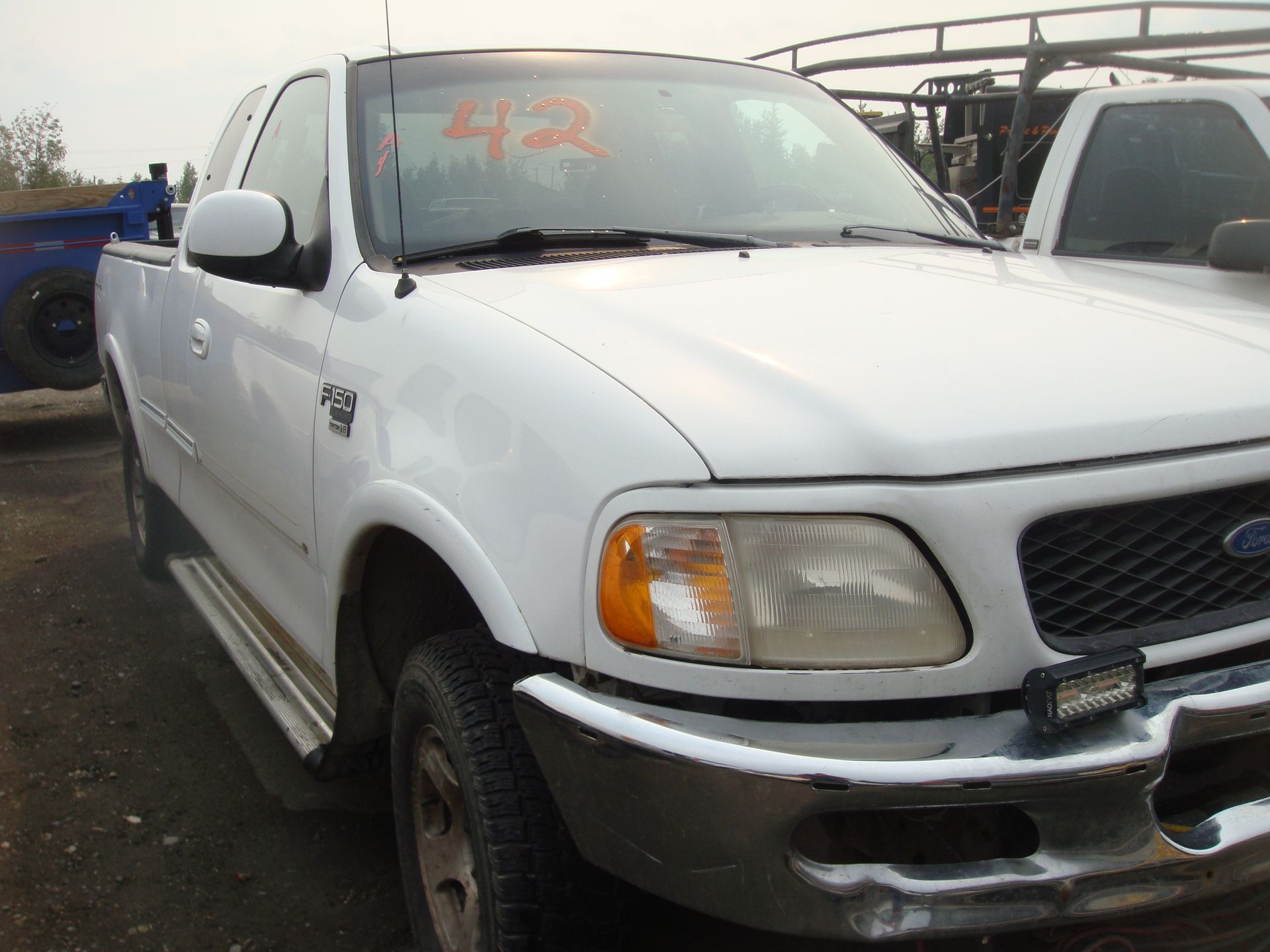 A white ford truck with the number 42 on the windshield