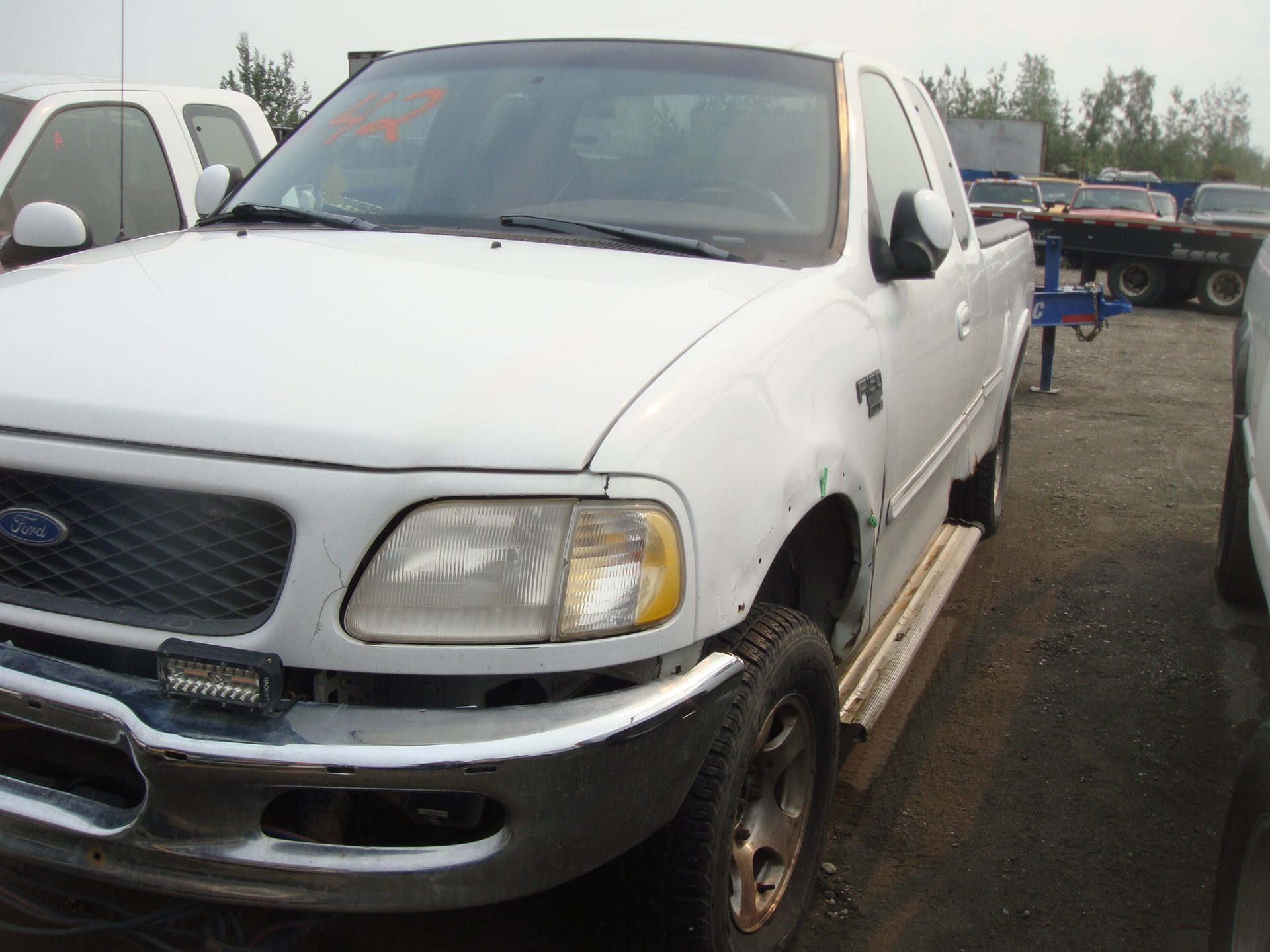 A white ford truck is parked in a parking lot