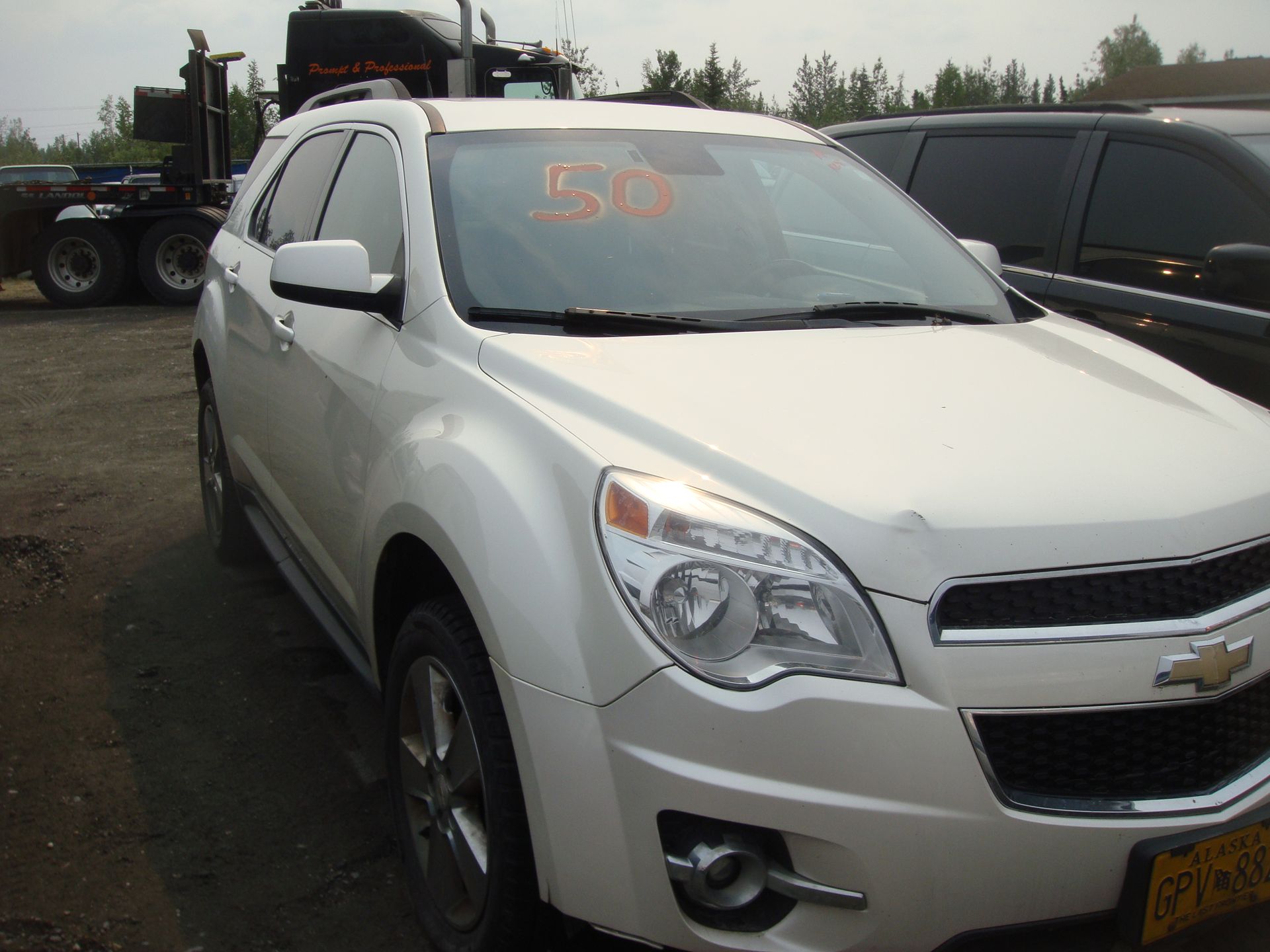 A white chevrolet equinox is parked in a lot