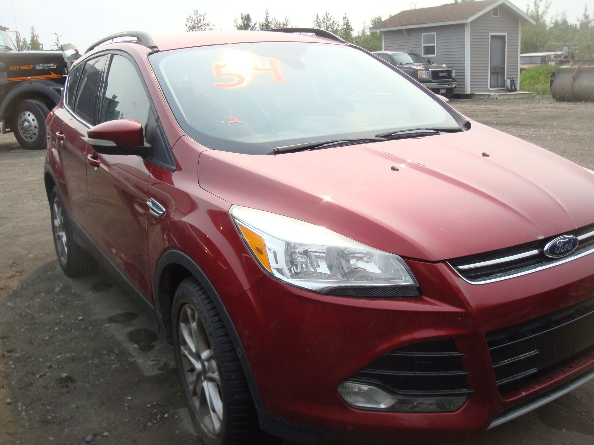 A red ford escape is parked in a parking lot