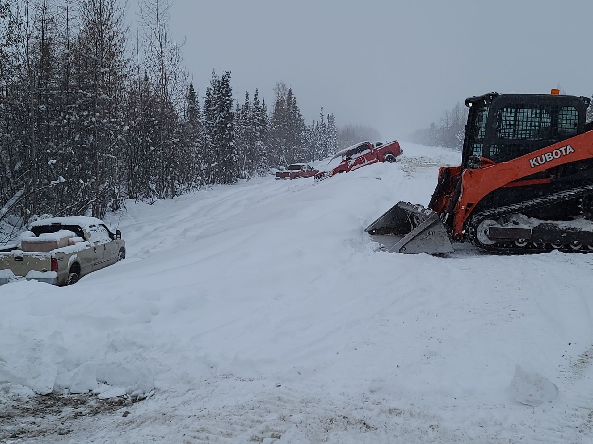 a kubota bulldozer is clearing snow from a road
