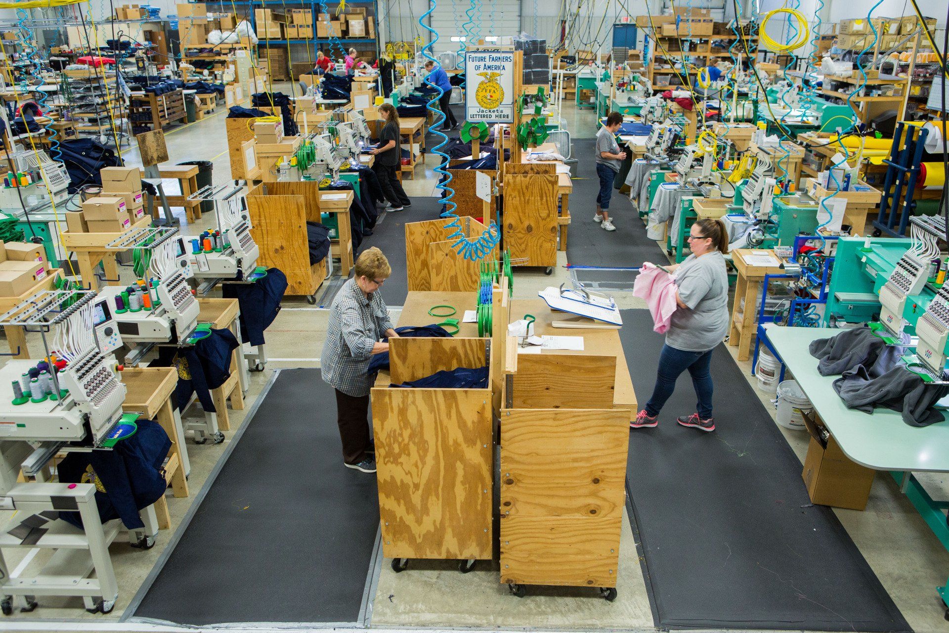 Fabric being sorted, jackets being sewed and dyed in a workshop.
