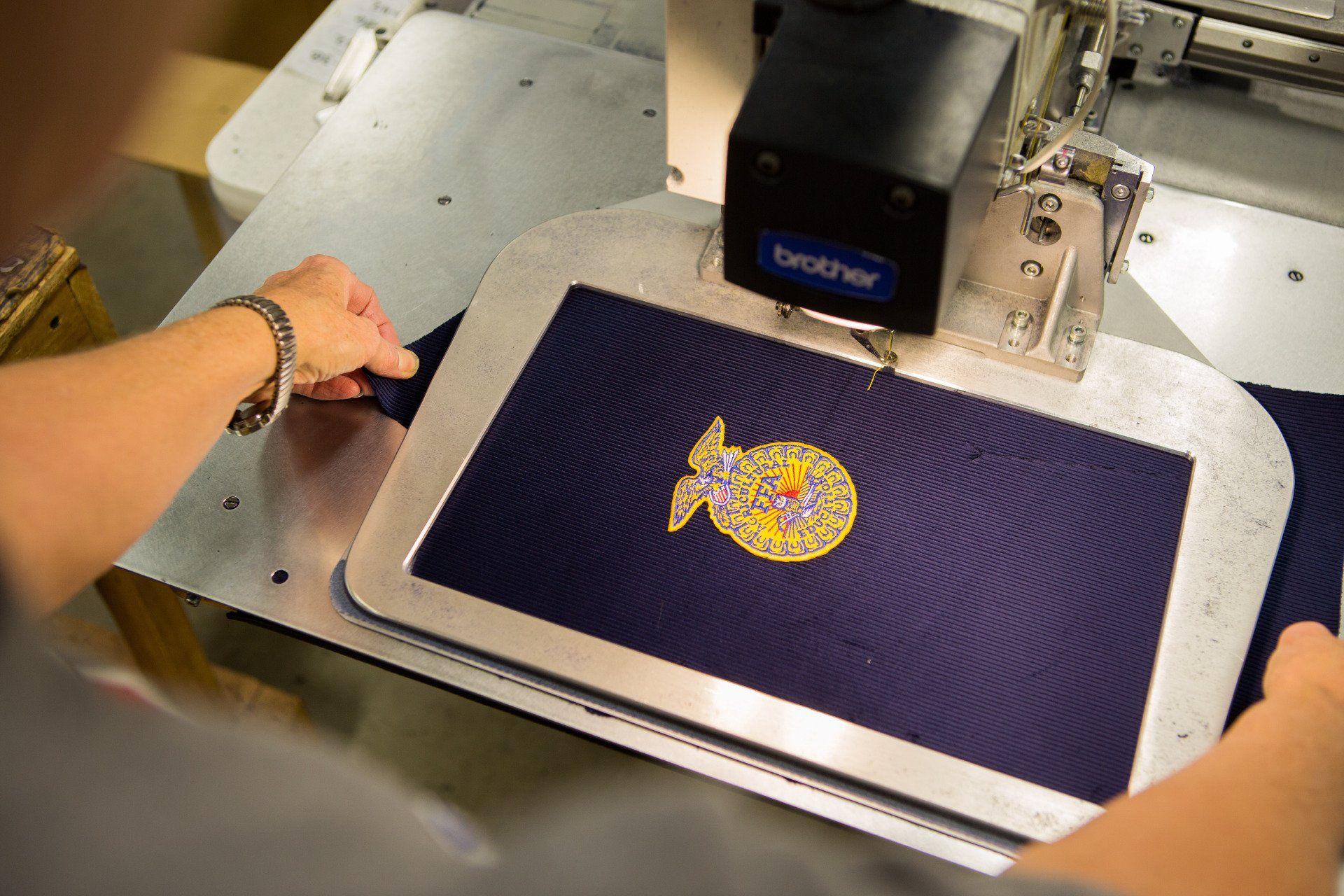A FFA patch being sewed into jacket fabric.