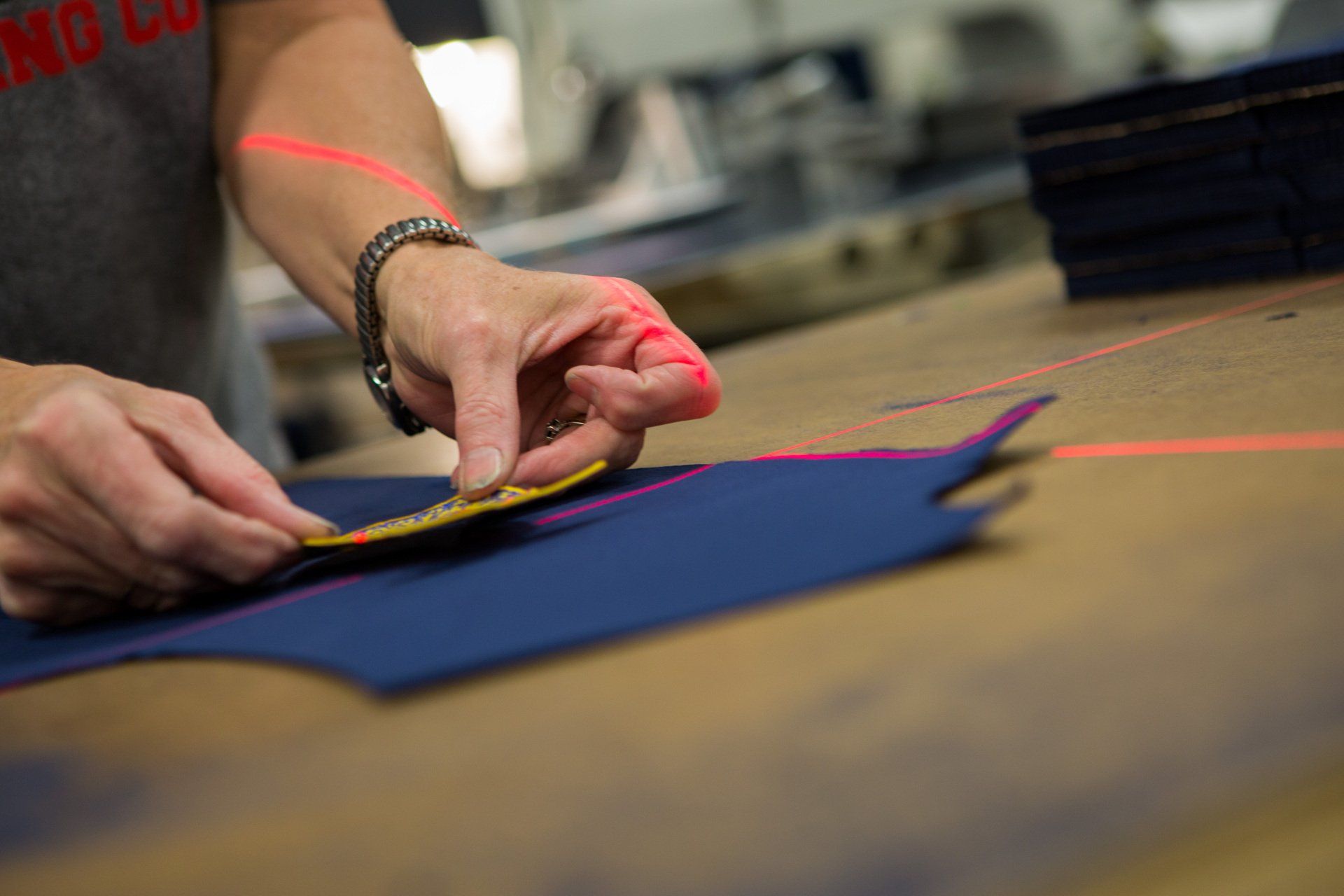 A person using laser measuring tool to place a FFA patch on jacket fabric.