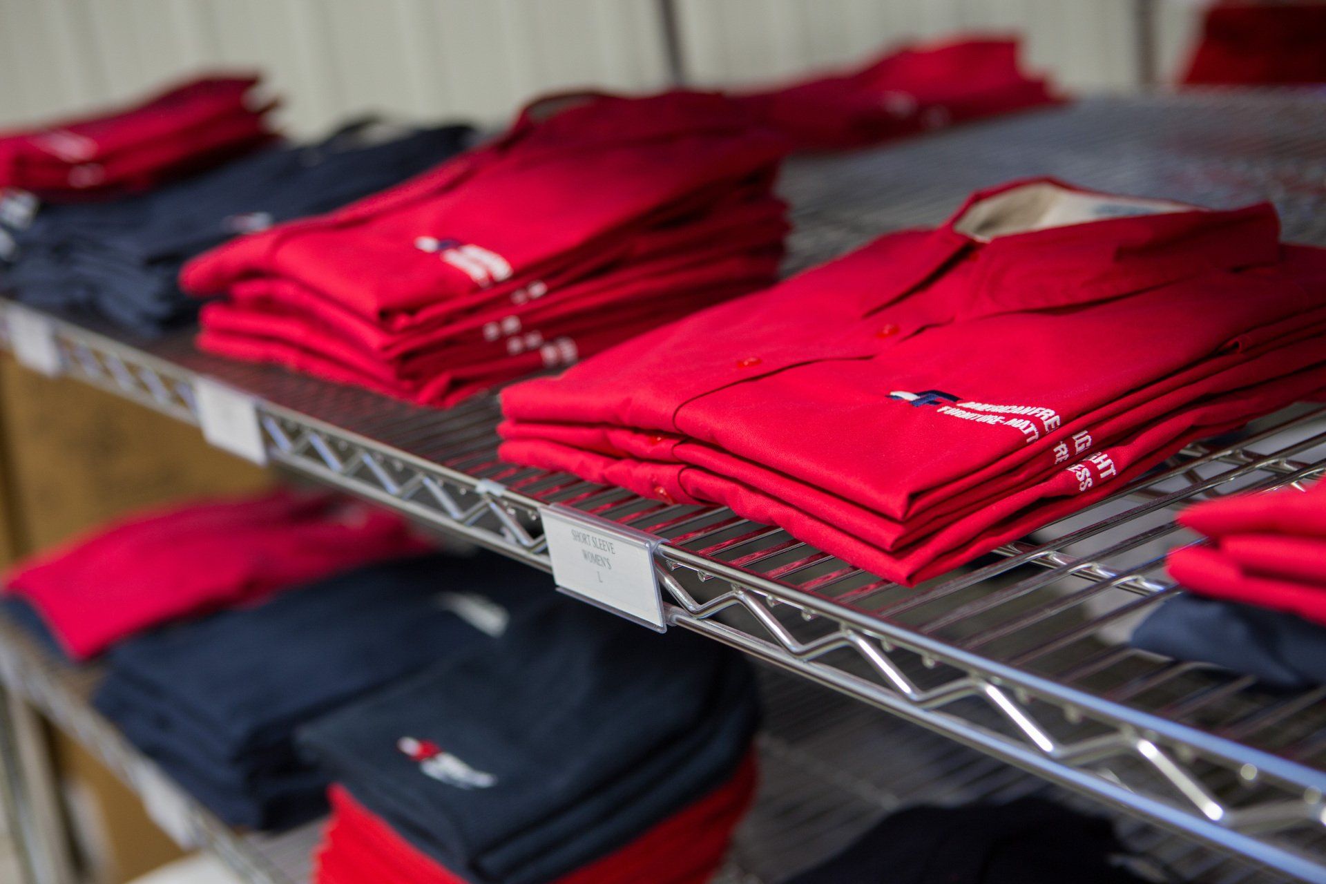 Folded custom shirts on a rack.