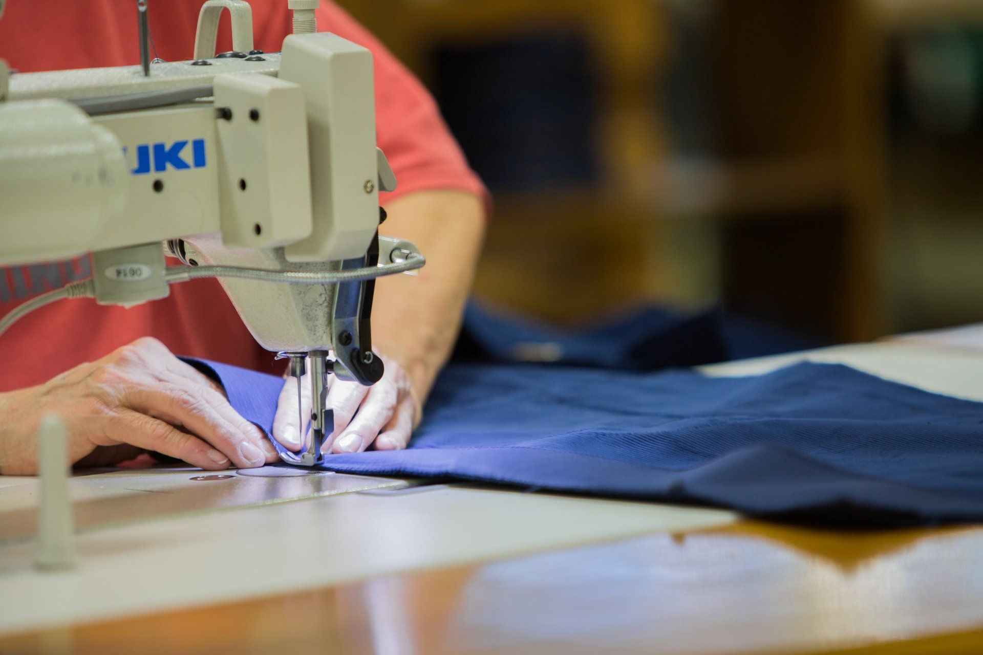 A person sewing two parts of a FFA jacket together.