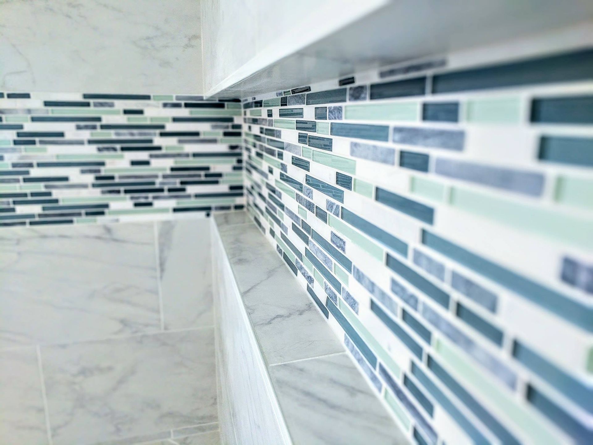 A close up of a tiled wall in a bathroom.