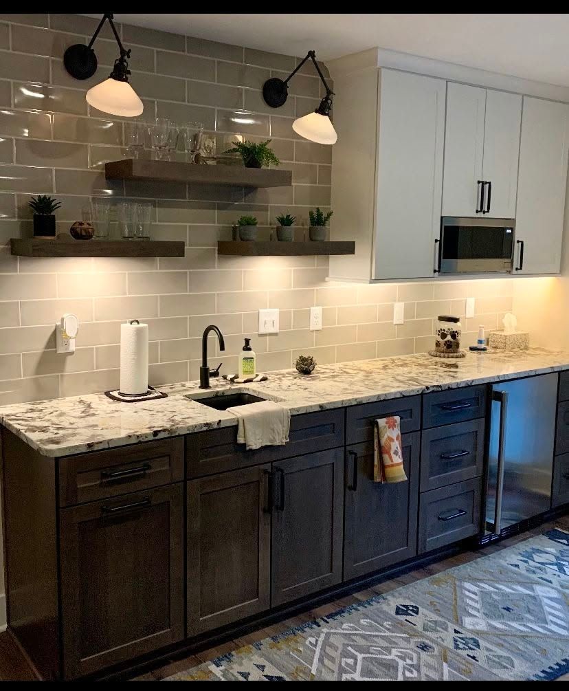 A kitchen with a sink , cabinets , and a microwave.