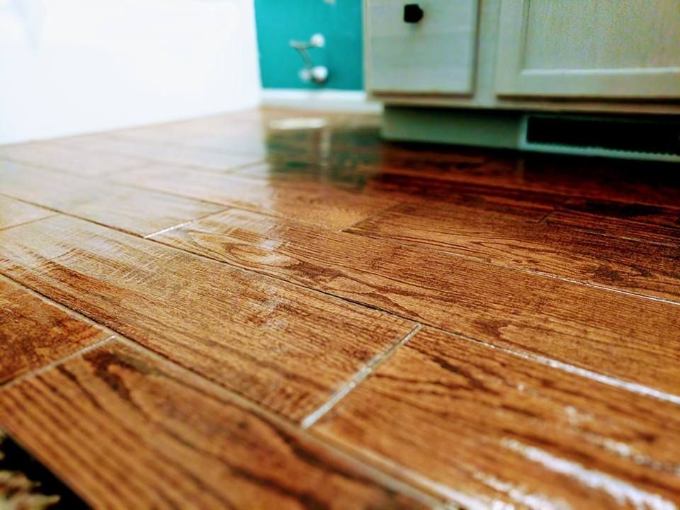 A close up of a wooden floor in a kitchen.