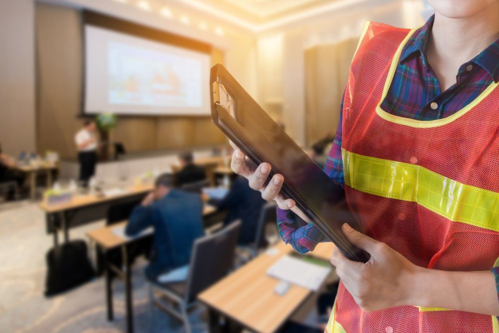 Person In Orange Safety Vest Holds A Clipboard — Wendy's Safety Services in Daly River, NT