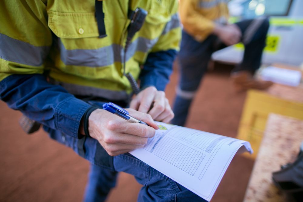 Person In Safety Vest And Blue Jeans Writing On A Clipboard Outdoors — Wendy's Safety Services in Daly River, NT