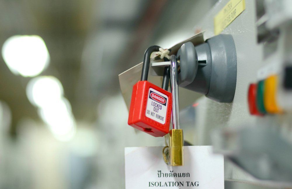 Red And Gold Padlocks On A Grey Electrical Switch, With An Attached Isolation Tag — Wendy's Safety Services in Moulden, NT