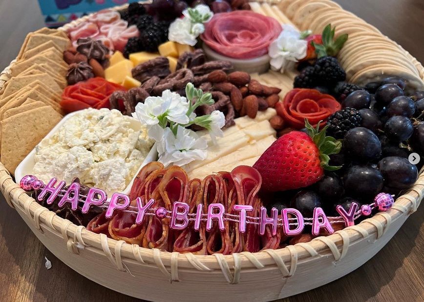 A wicker basket filled with a variety of fruits and vegetables with the words happy birthday written on it.