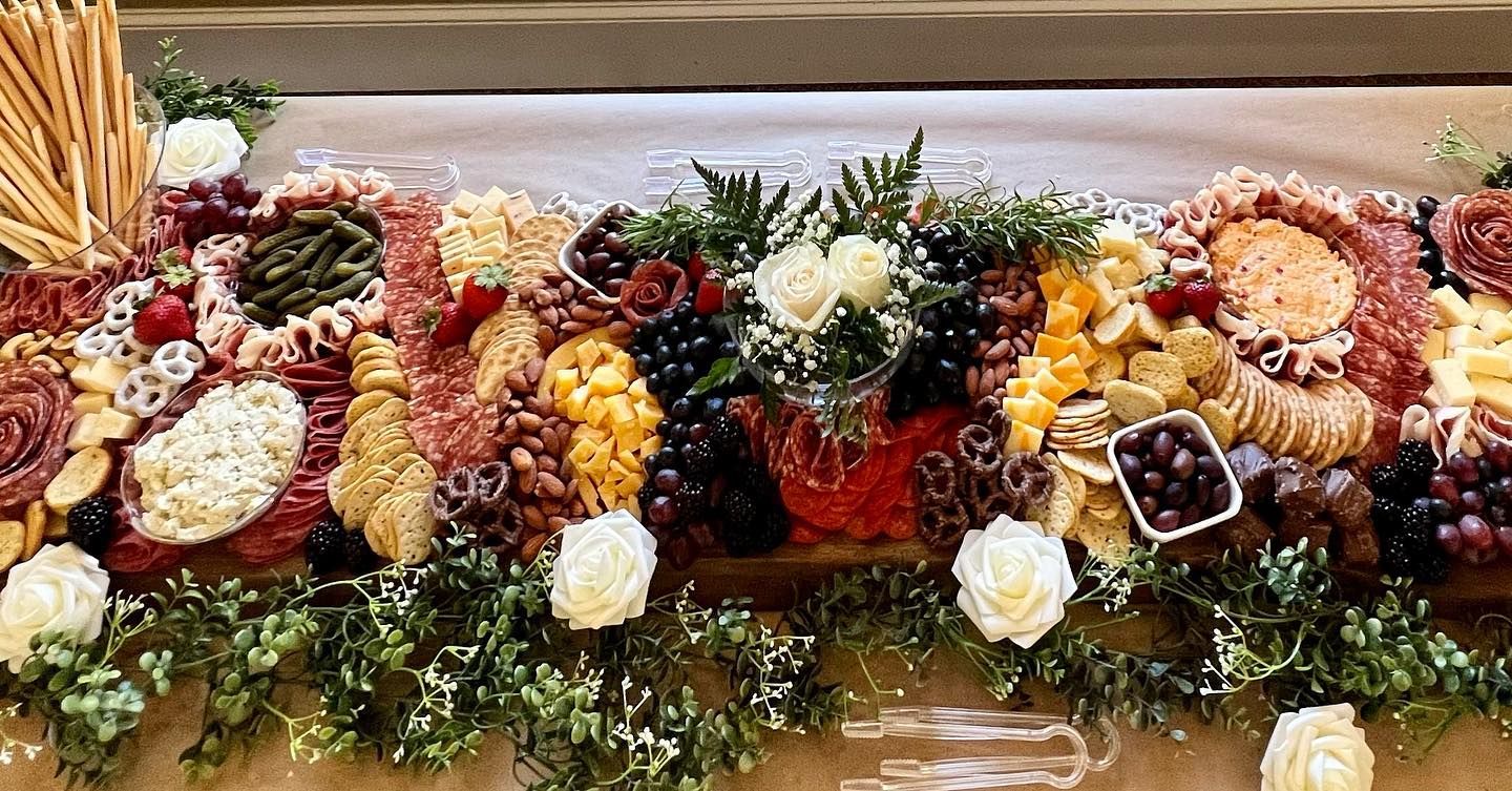A long table topped with a variety of food and flowers.