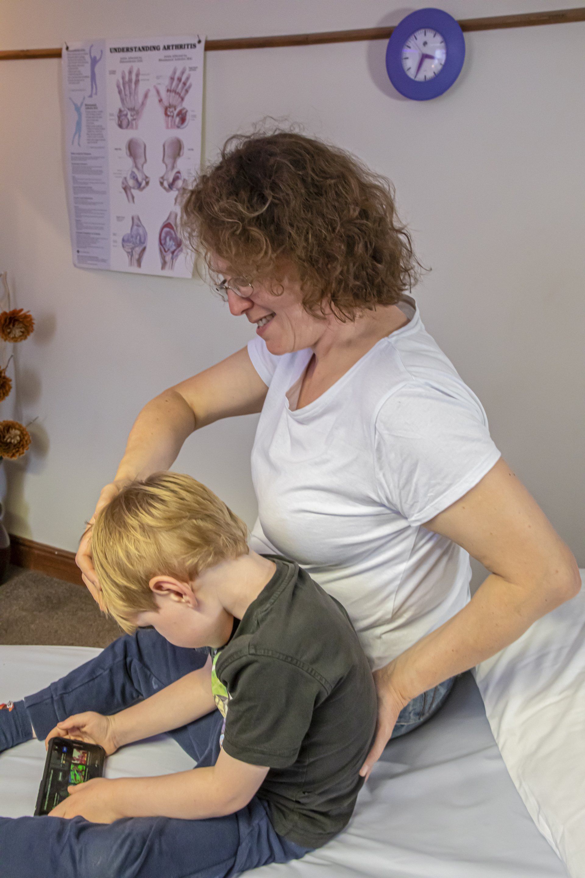PAEDIATRIC OSTEOPATHY - physiotherapist helping patient with back pain