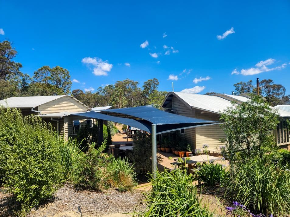 A House with A Shaded Area in Front of It Surrounded by Trees and Bushes — New England Shade Sails in North Tamworth, NSW