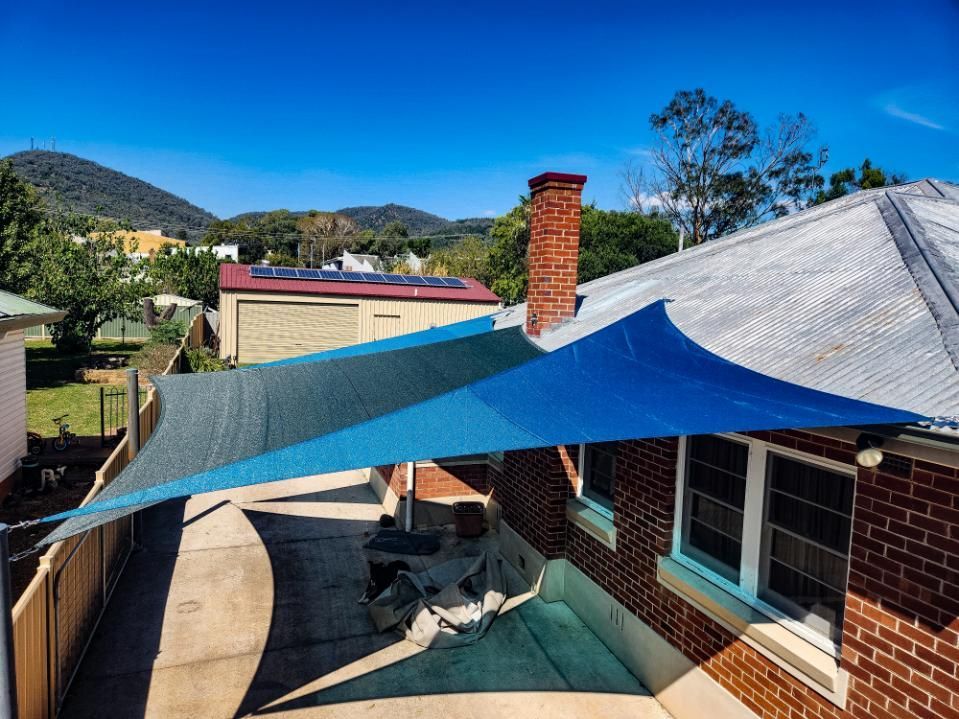 A Blue Shade Sail Is Sitting on Top of A Brick House — New England Shade Sails in Armidale, NSW