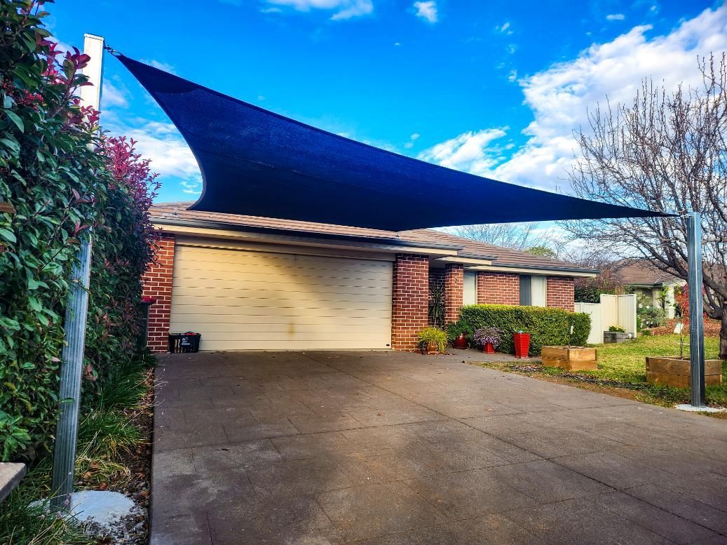 A Blue Canopy Is Covering a Driveway in Front of A House — New England Shade Sails in Armidale, NSW