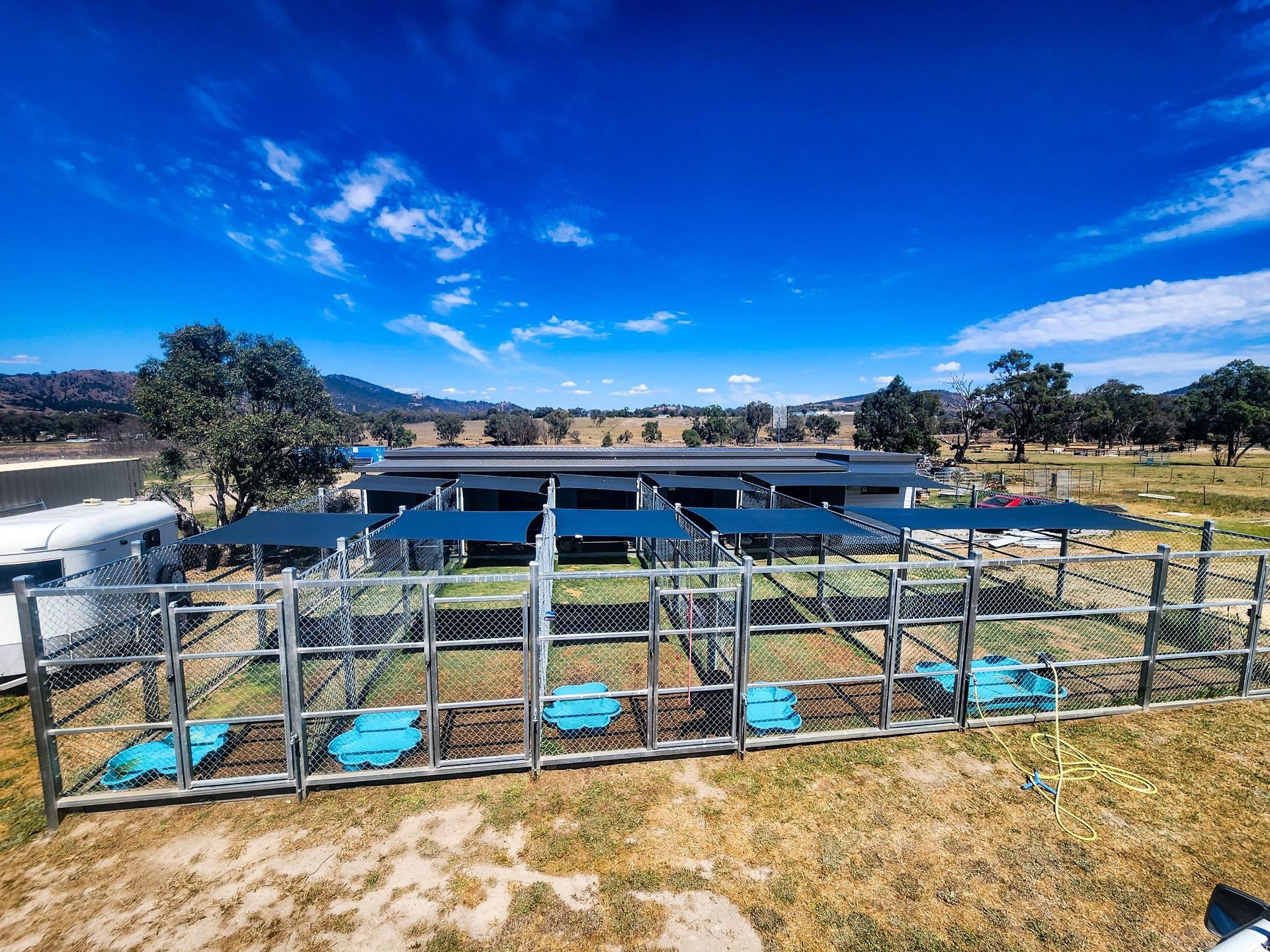 A Triangle Shaped Umbrella with A Sailboat on It Is Sitting in Front of A Building — New England Shade Sails in North Tamworth, NSW