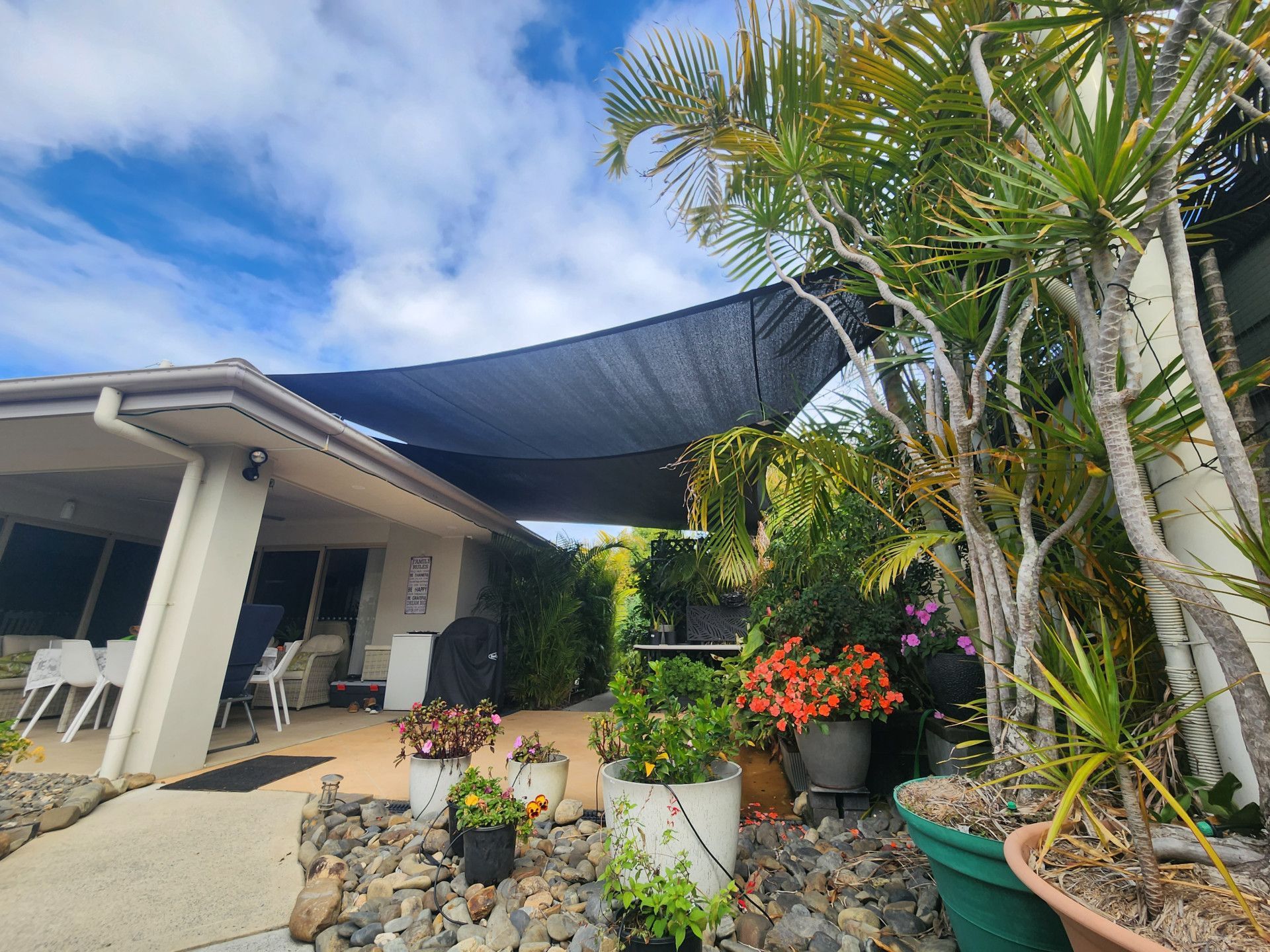 A Patio with Potted Plants and A Table and Chairs Under a Canopy — New England Shade Sails in North Tamworth, NSW