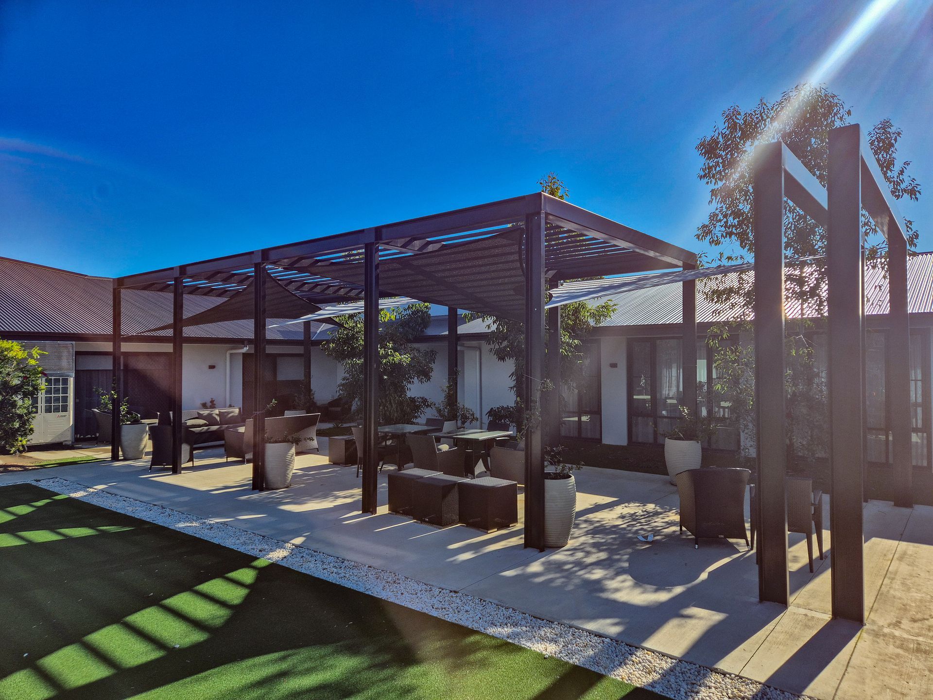A House with A Shaded Area in Front of It Surrounded by Trees and Bushes — New England Shade Sails in North Tamworth, NSW 