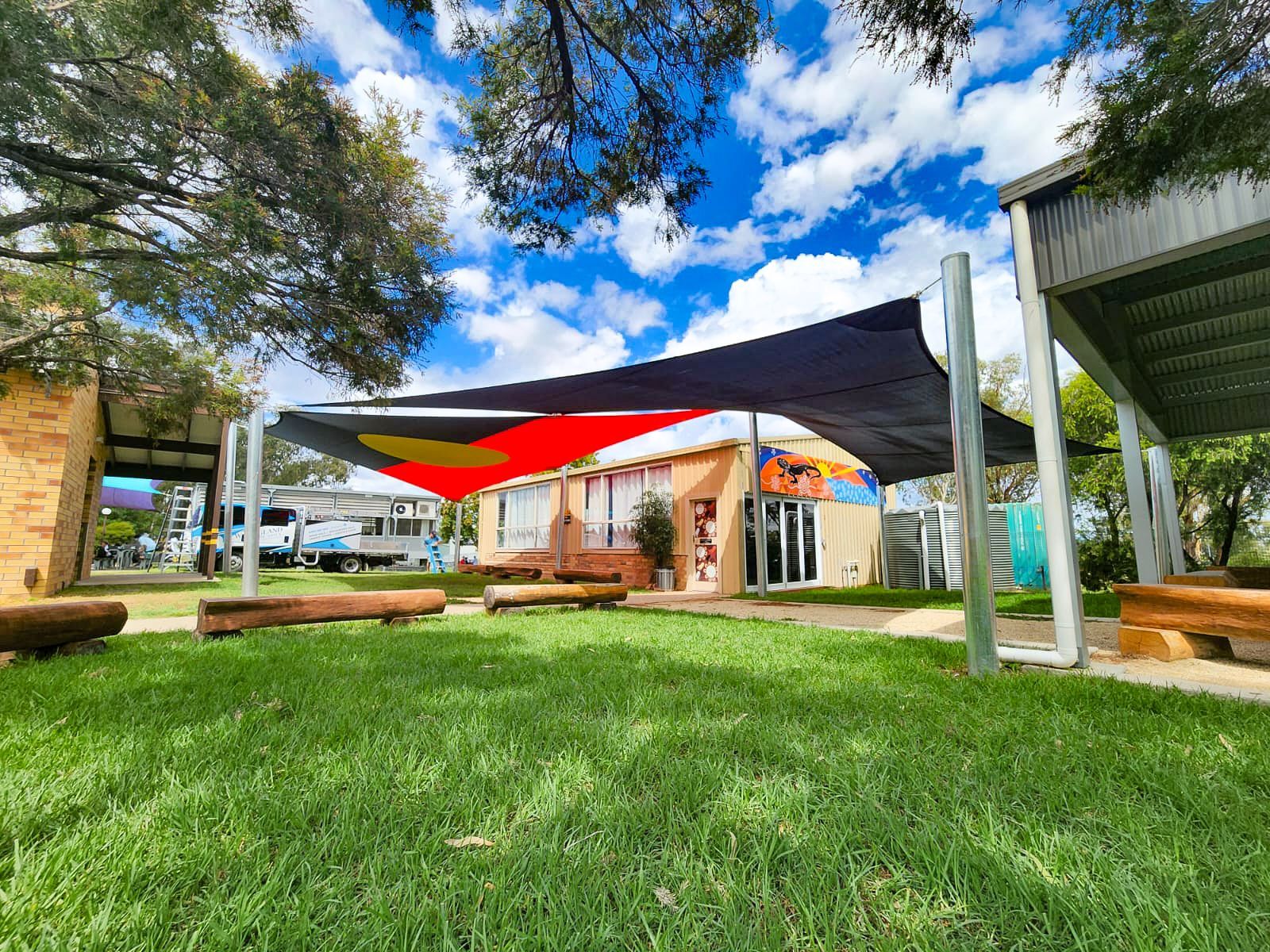 A Blue and Red Shade Sail Is Hanging Over a Playground  — New England Shade Sails in North Tamworth, NSW