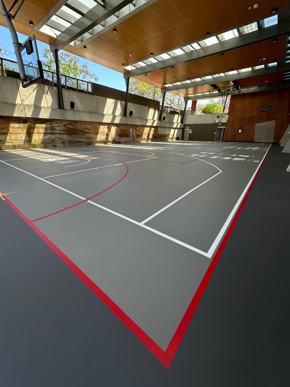 A large indoor basketball court with a red line on the floor.