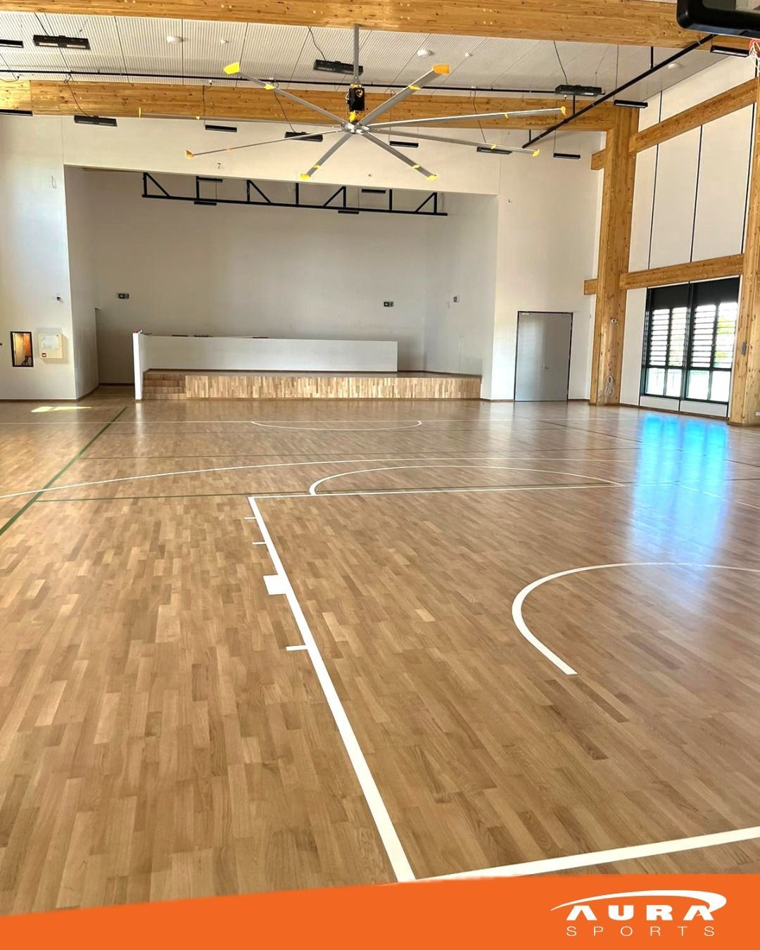 an empty gym with a wooden floor and a basketball court
