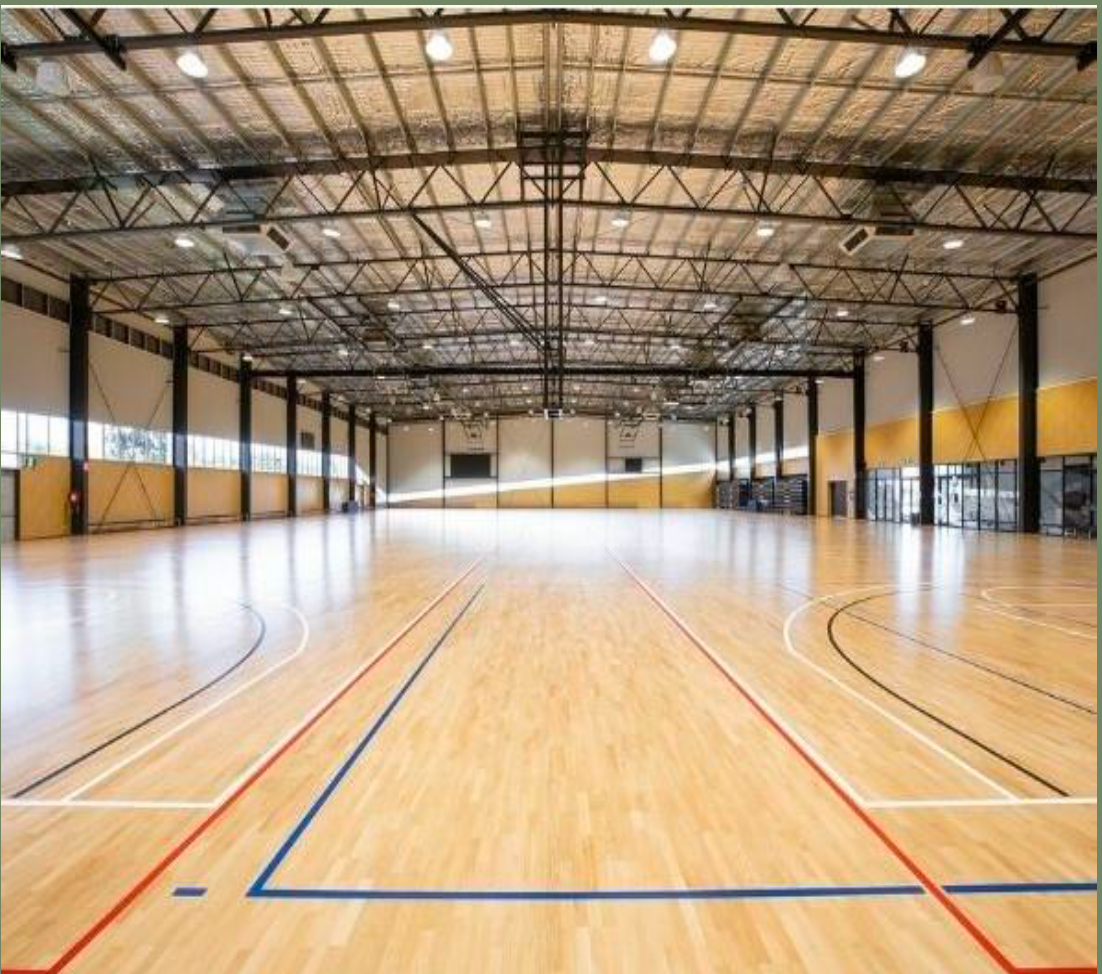 A large indoor basketball court with a wooden floor