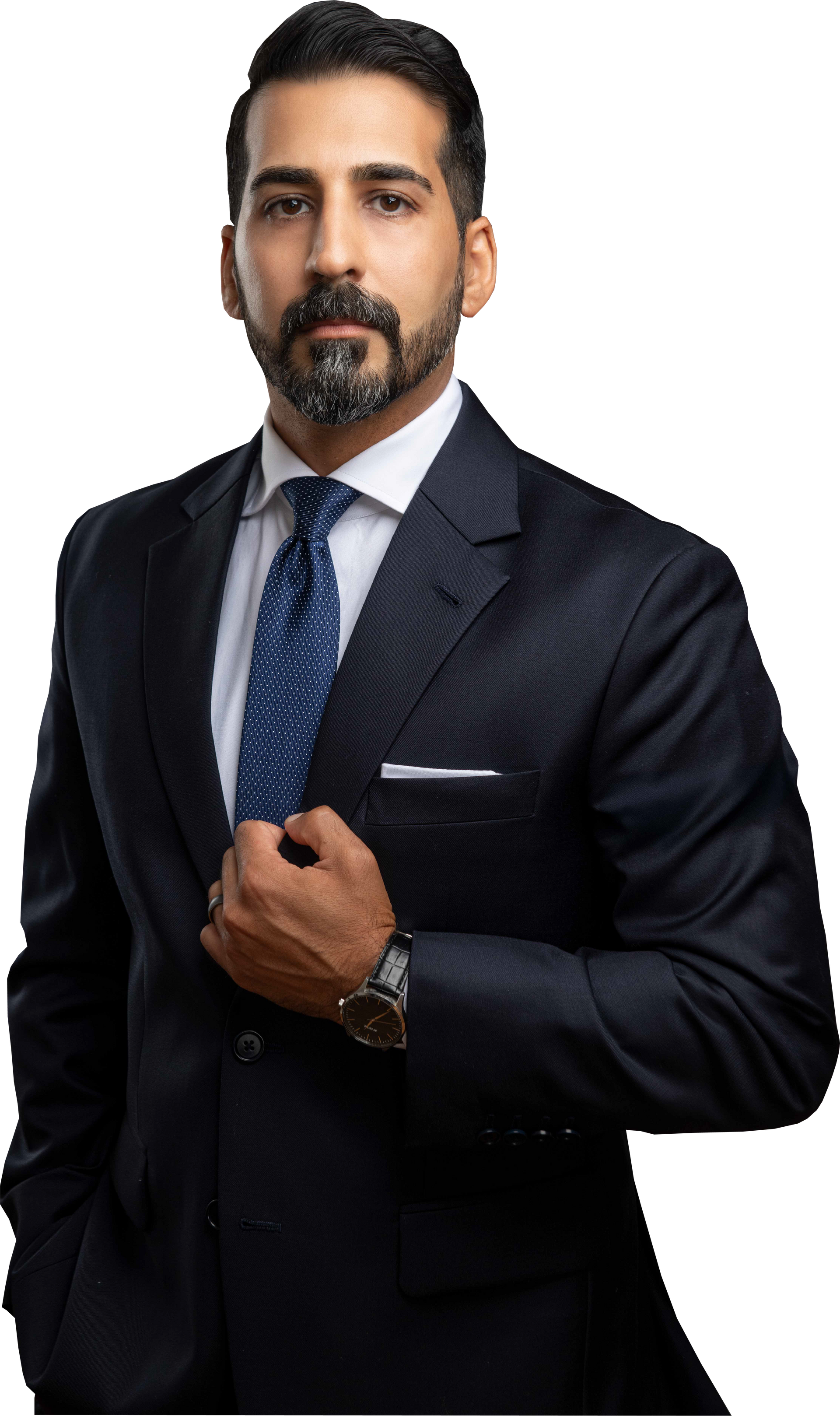 Man in a suit, navy, looking at the viewer. Hand on his chest, white pocket square, dotted tie, beard.