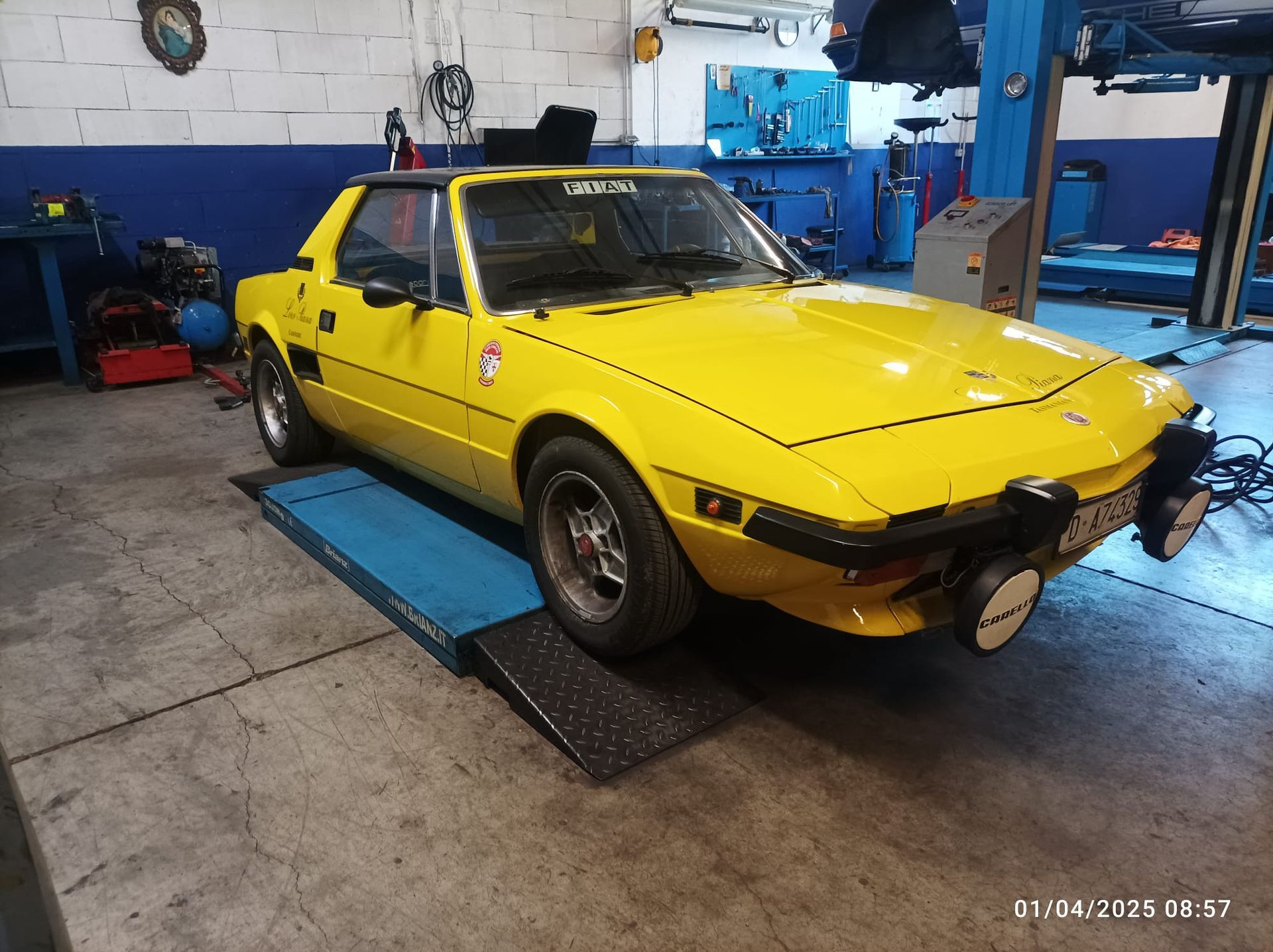 Un'auto gialla è parcheggiata su una rampa in un garage