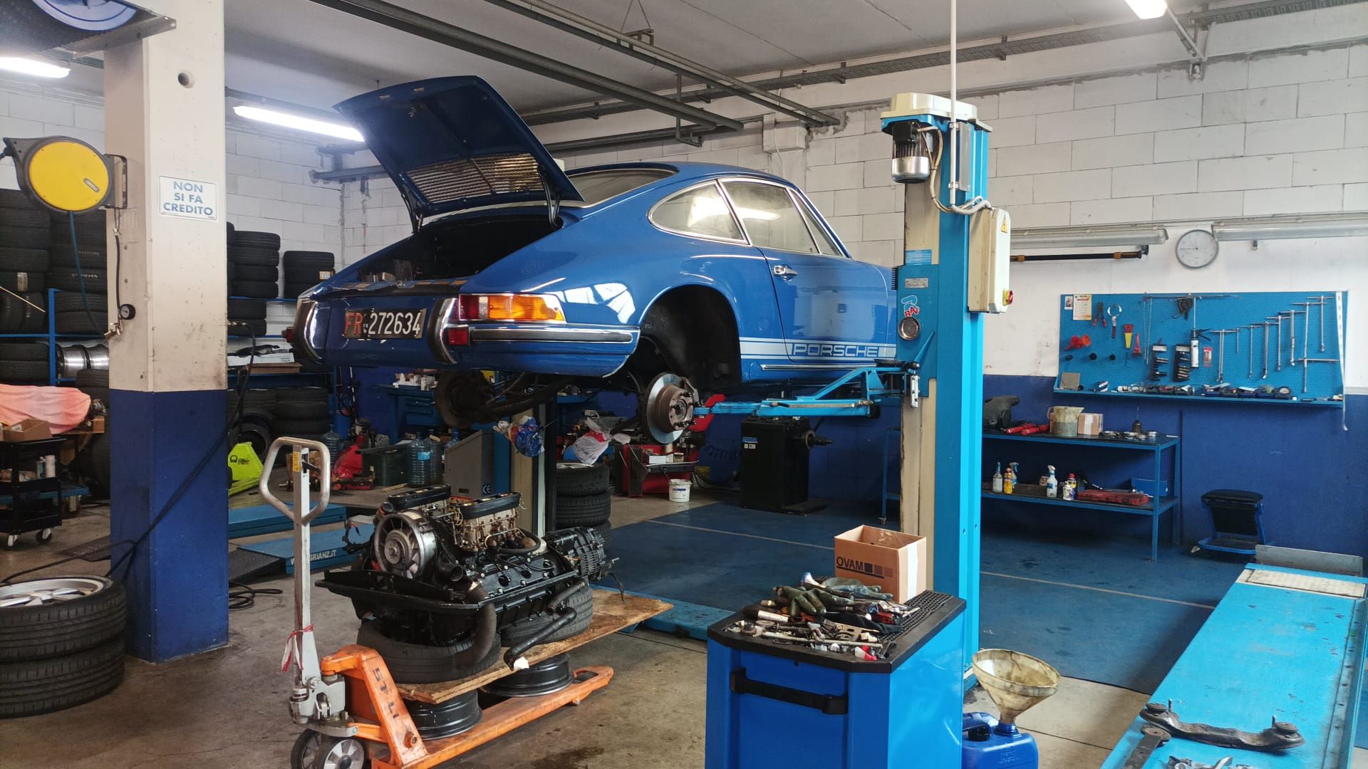 Un'auto blu è su un ascensore in un garage