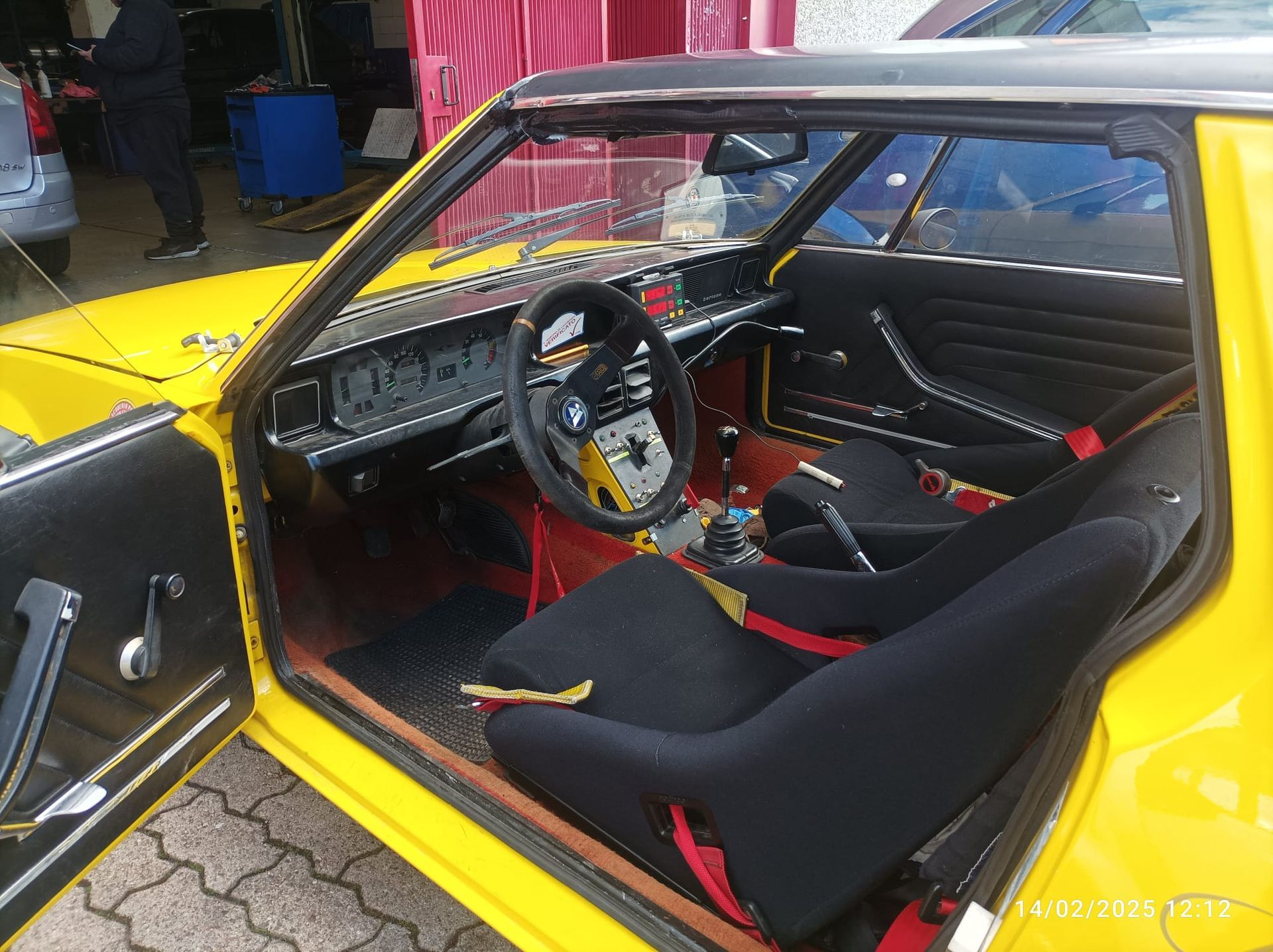 Un'auto gialla con sedili neri e un volante