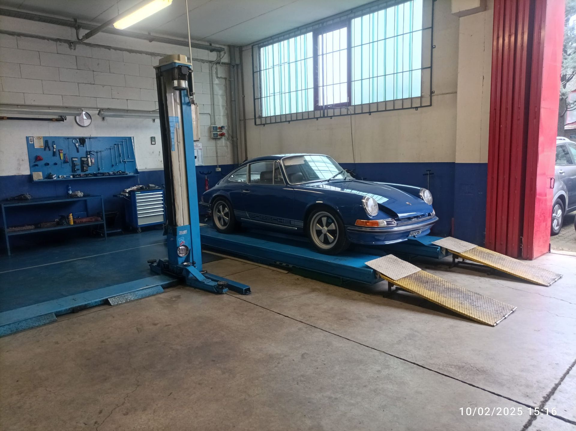 Un'auto blu è su un ascensore in un garage