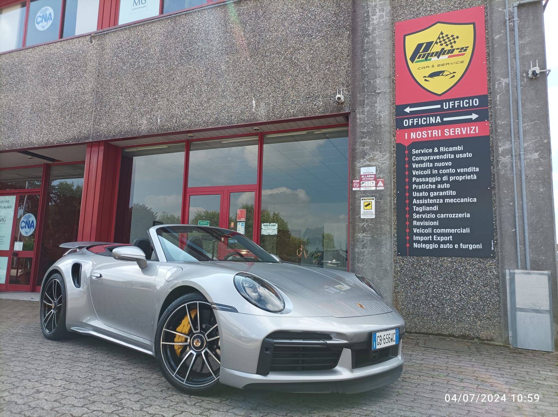 Un'auto sportiva argentata è parcheggiata davanti a un edificio
